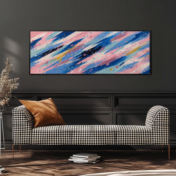 a modern living room with a black and white checkered sofa, a stack of books, and a large abstract painting hanging on the wall above the sofa.