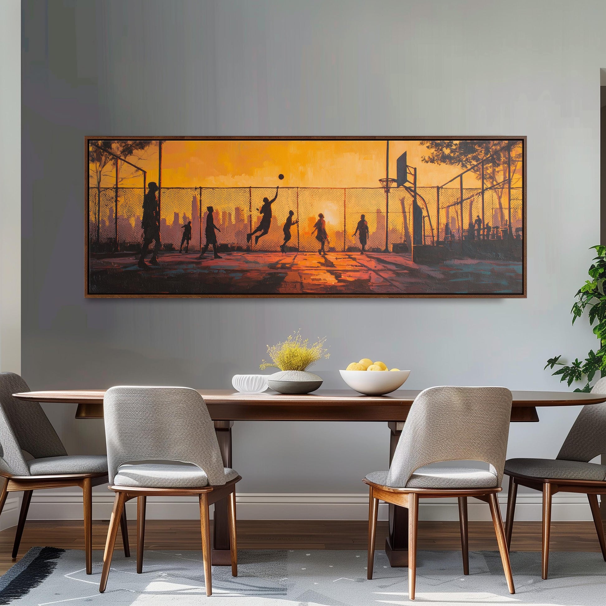 a dining room with a large painting of people playing basketball on the wall above a wooden dining table with four chairs.