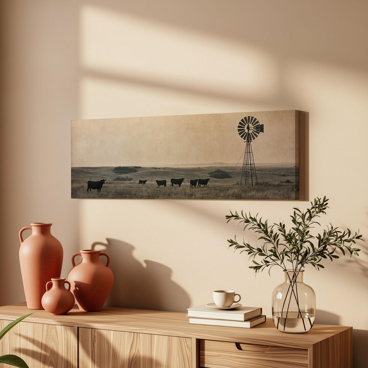 Black cattle grazing by a windmill on the prairie long horizontal canvas print above a wooden sideboard