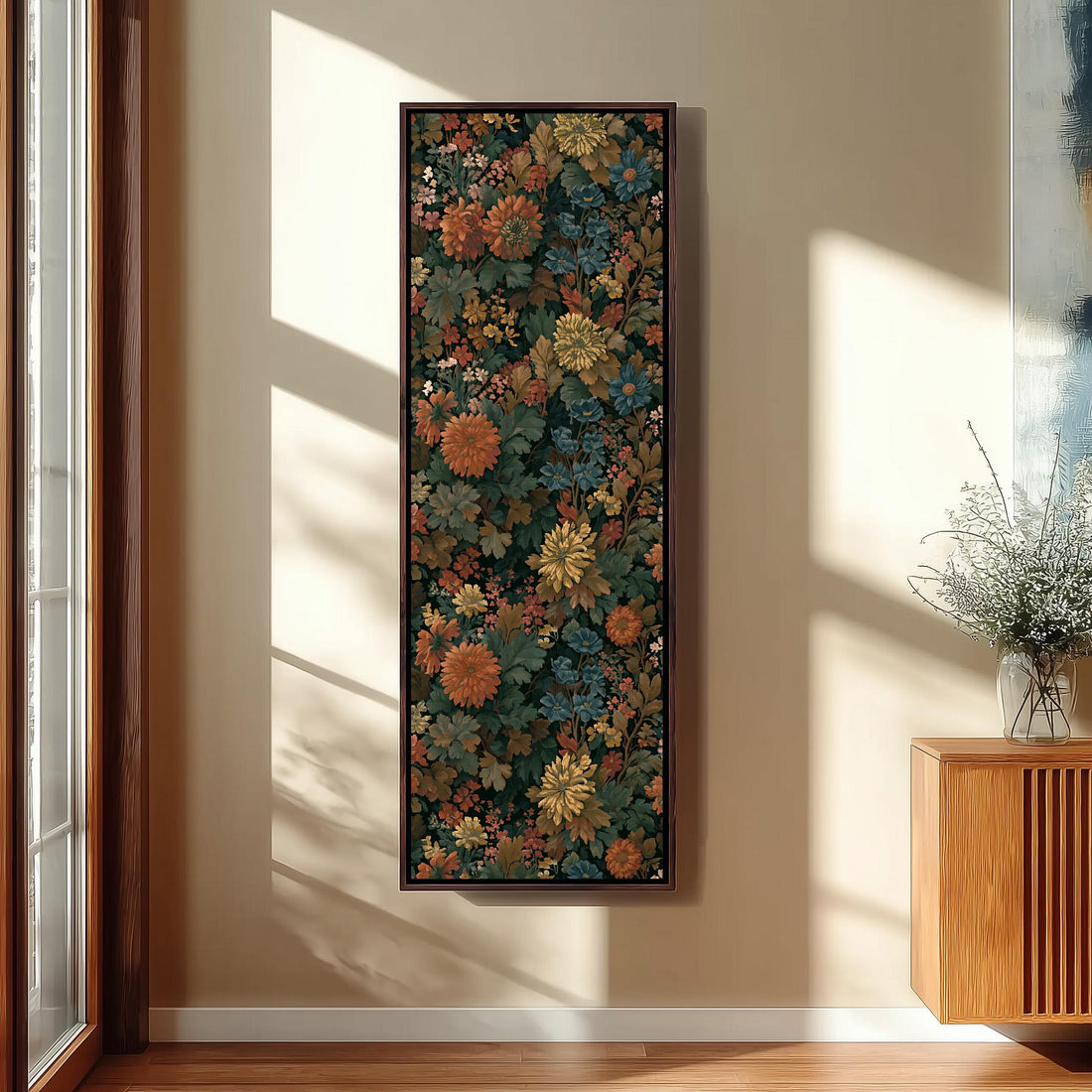 a large, colorful floral painting hanging on a wall in a room with a wooden cabinet below it.