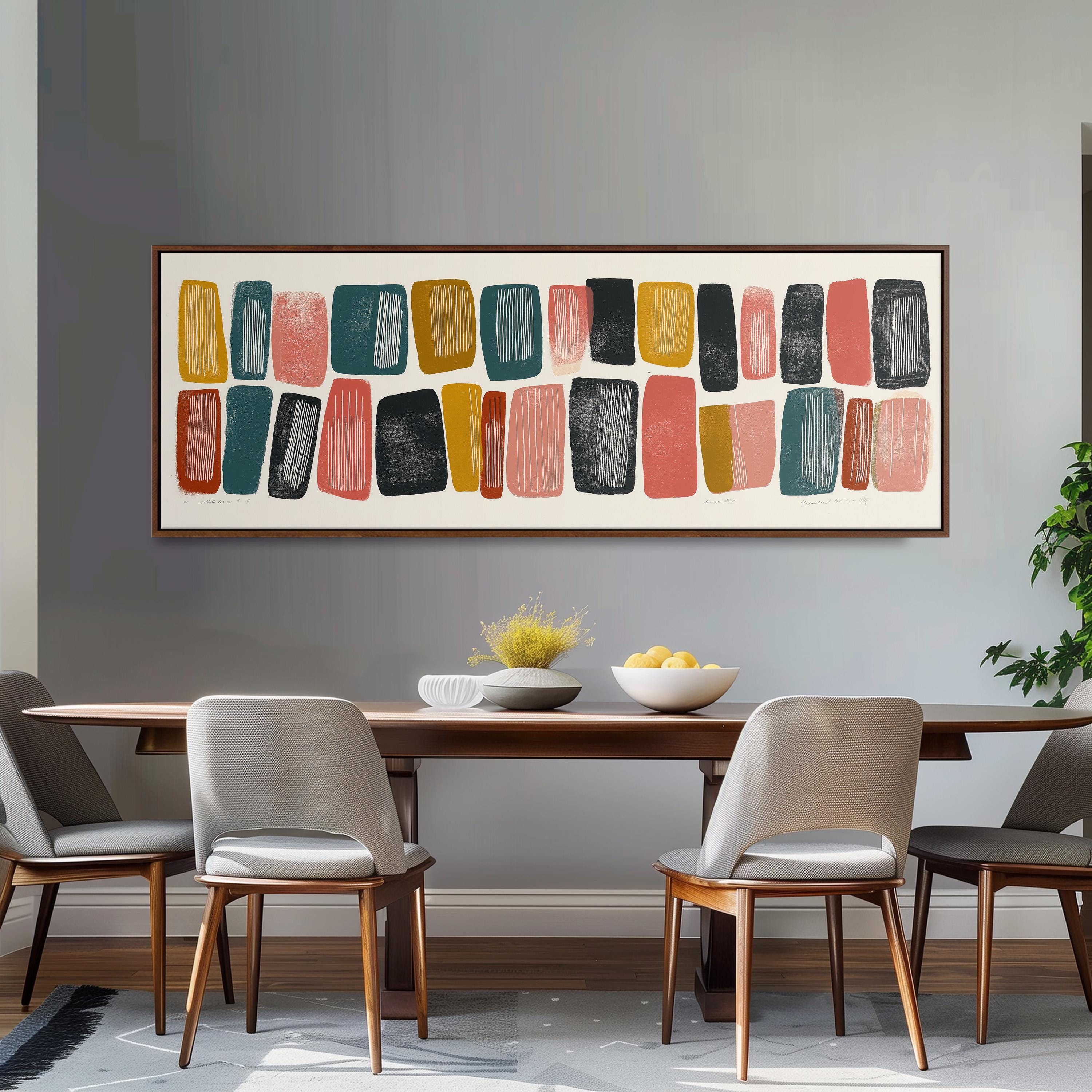 a modern dining room with a wooden table and four chairs. Above the table, there is a large abstract painting with various shapes and colors. The table is set with a bowl of fruit and a vase of flowers, creating a welcoming and stylish atmosphere.
