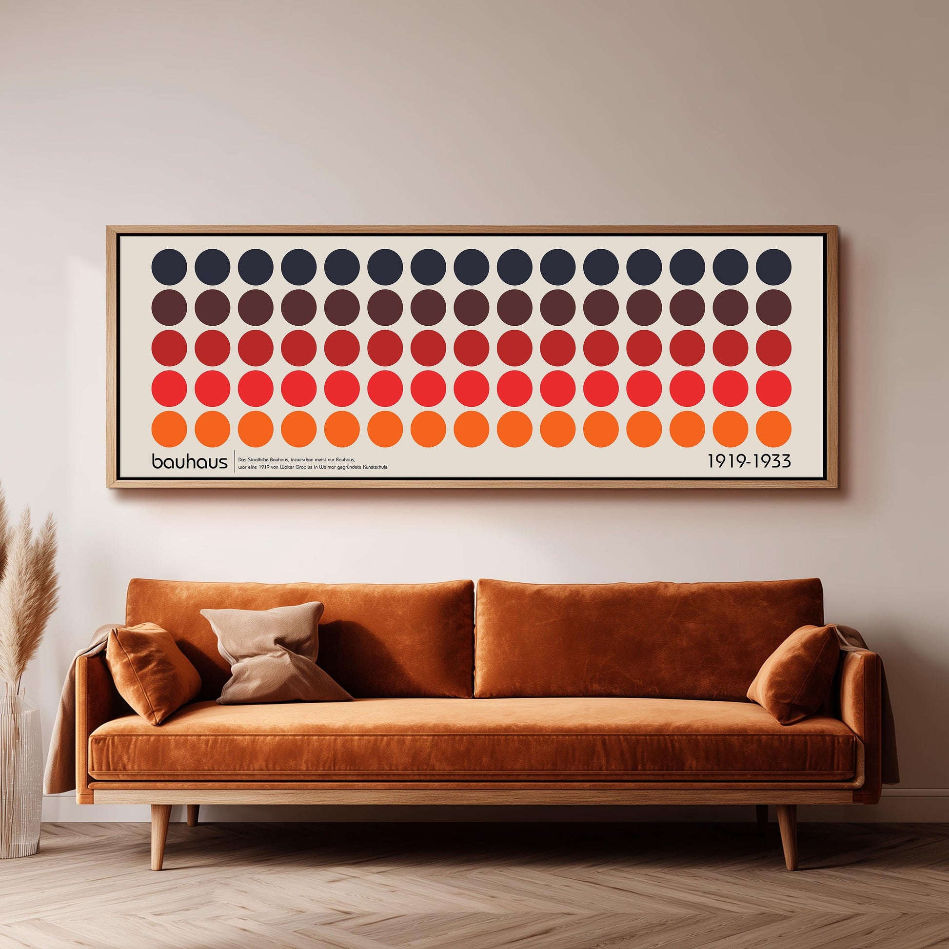 a large framed poster of a repeating pattern of circles in various colors, hanging on a wall above a brown sofa.