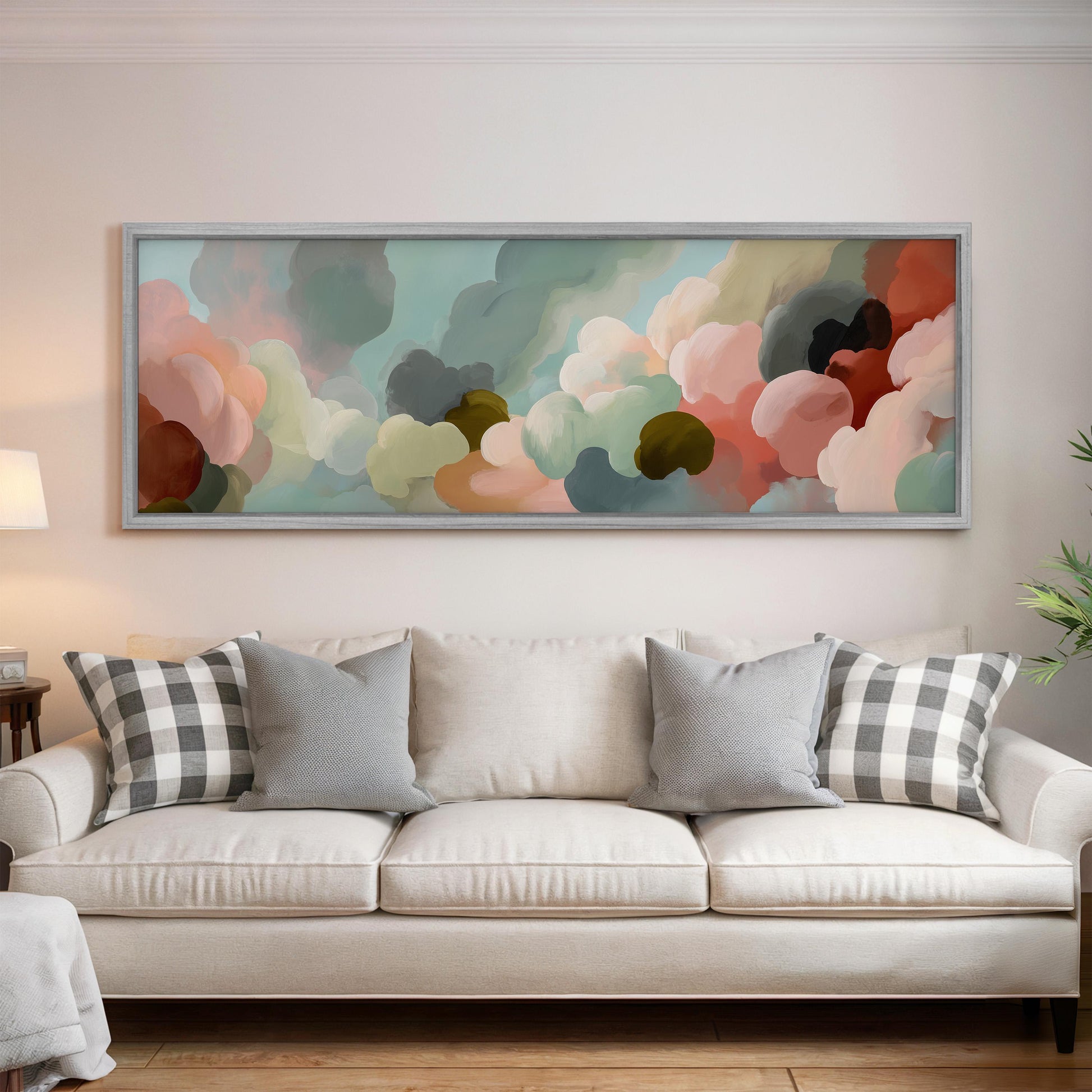 a large, colorful painting hanging on a wall above a white couch with gray and black plaid throw pillows.
