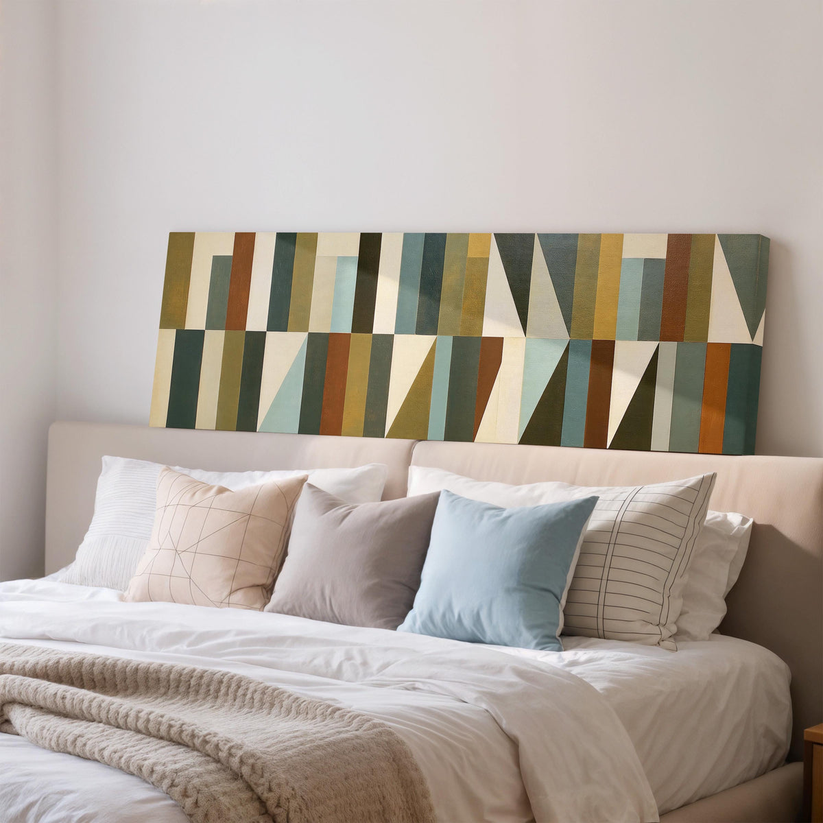Earth tone geometric triangles wide panoramic canvas print above a bed in a bedroom