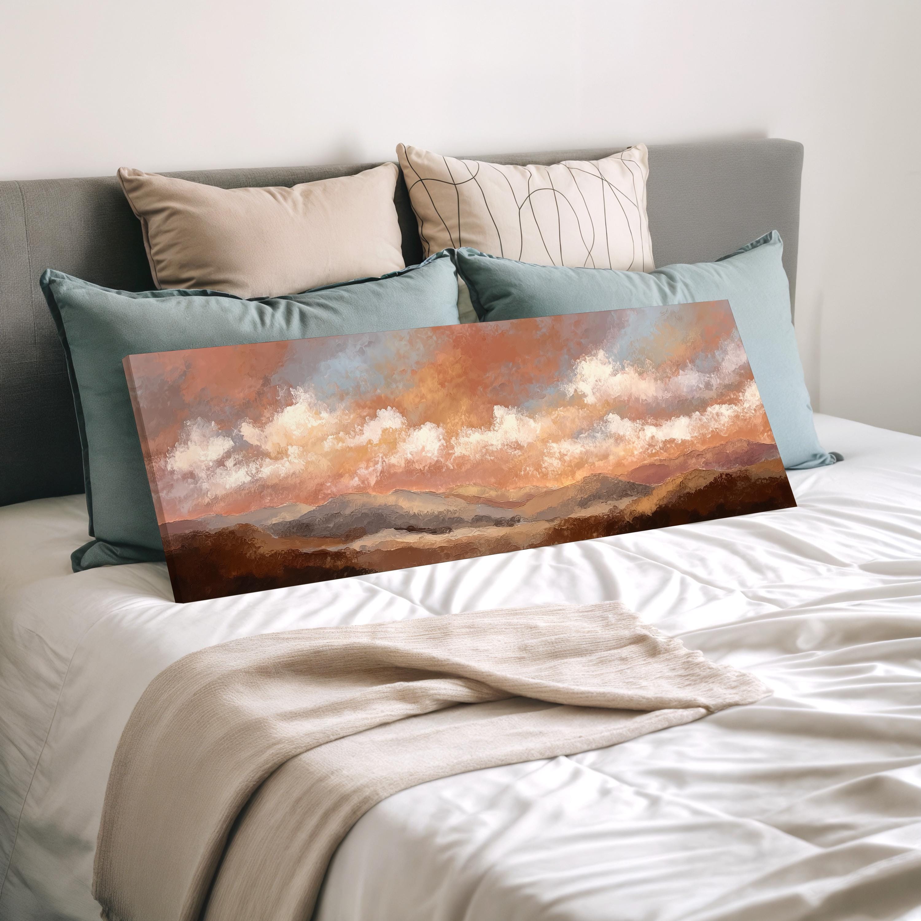 a large landscape painting displayed on a bed, with a gray headboard and a white comforter.