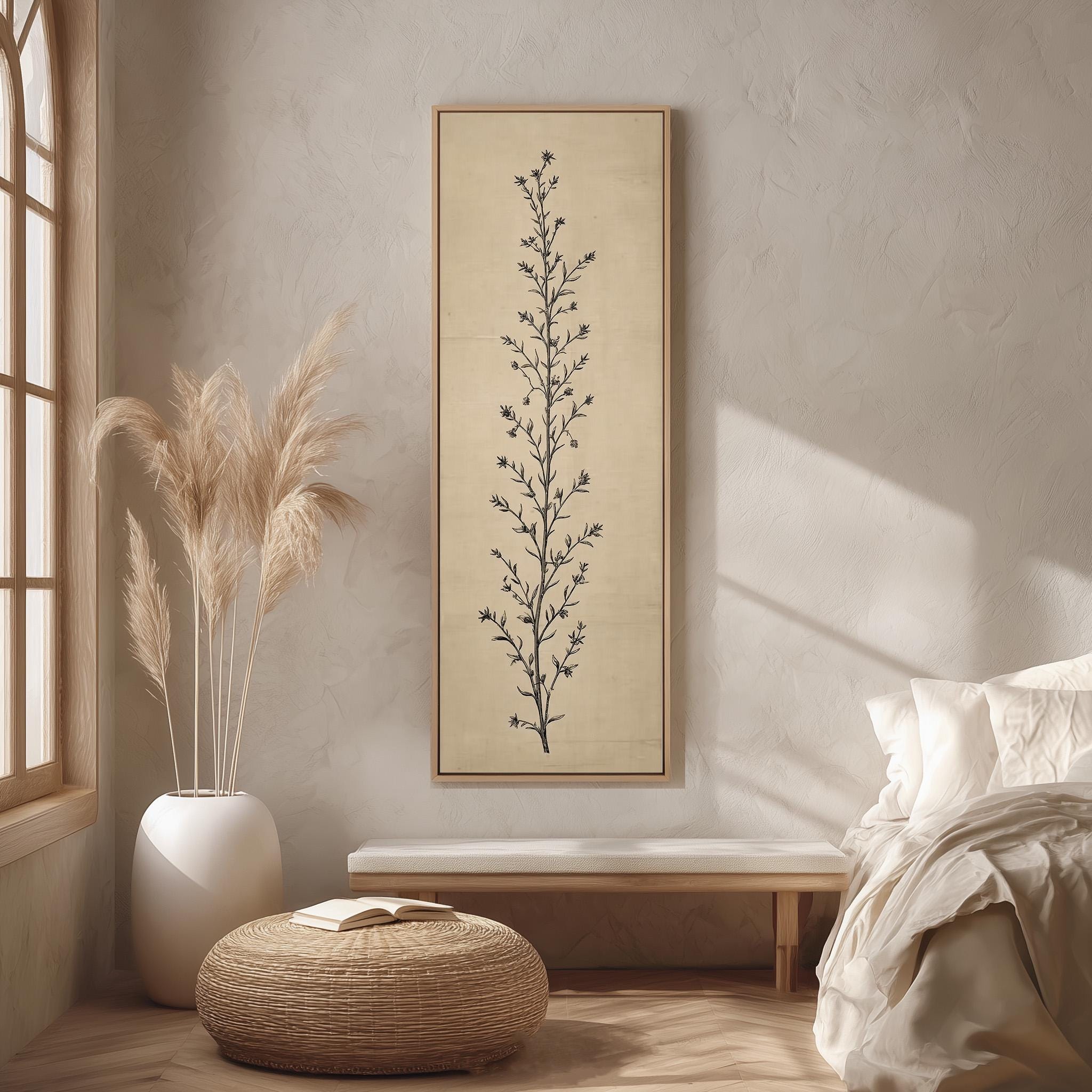 a serene and minimalist bedroom interior, featuring a large framed artwork of a tree on the wall, a white bed with a white pillow, a white vase with tall potted plants, and a woven ottoman.