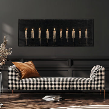 Ten lit candles on black long horizontal canvas print above a sofa in a living room
