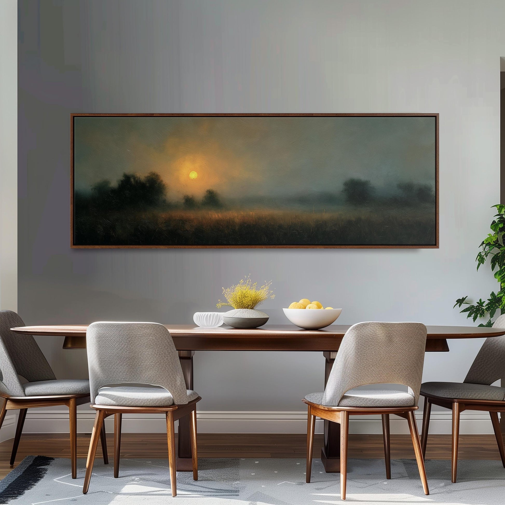 a dining room with a large painting of a sunrise over a field hanging on the wall above a wooden dining table with four chairs. The table is set with a bowl of fruit and a vase of flowers, creating a cozy and inviting atmosphere.