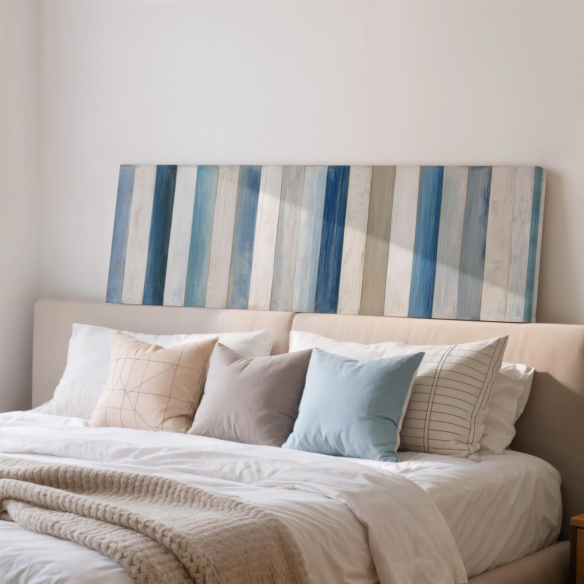 a cozy bedroom with a bed adorned with a white comforter and a variety of colorful pillows. Above the bed, there is a wooden headboard with vertical blue and white striped panels.