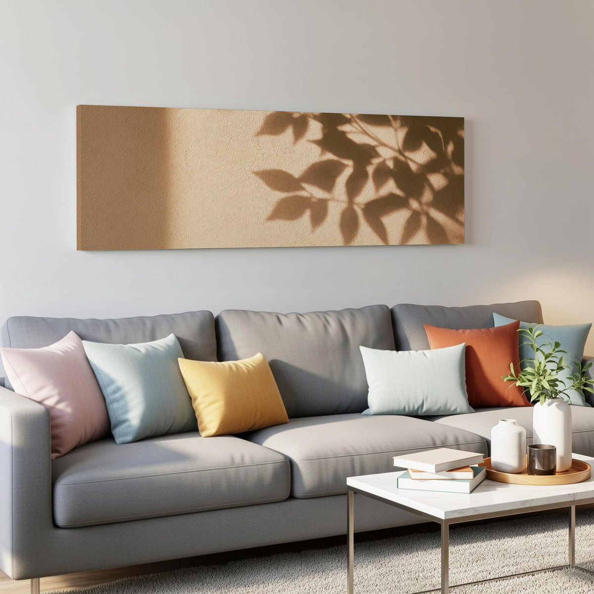 Leaf shadows on a golden plaster wall panoramic canvas print above a grey sofa in a living room