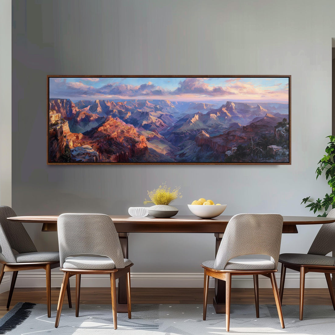 a large painting of a mountainous landscape hanging on a wall above a wooden dining table with four chairs.