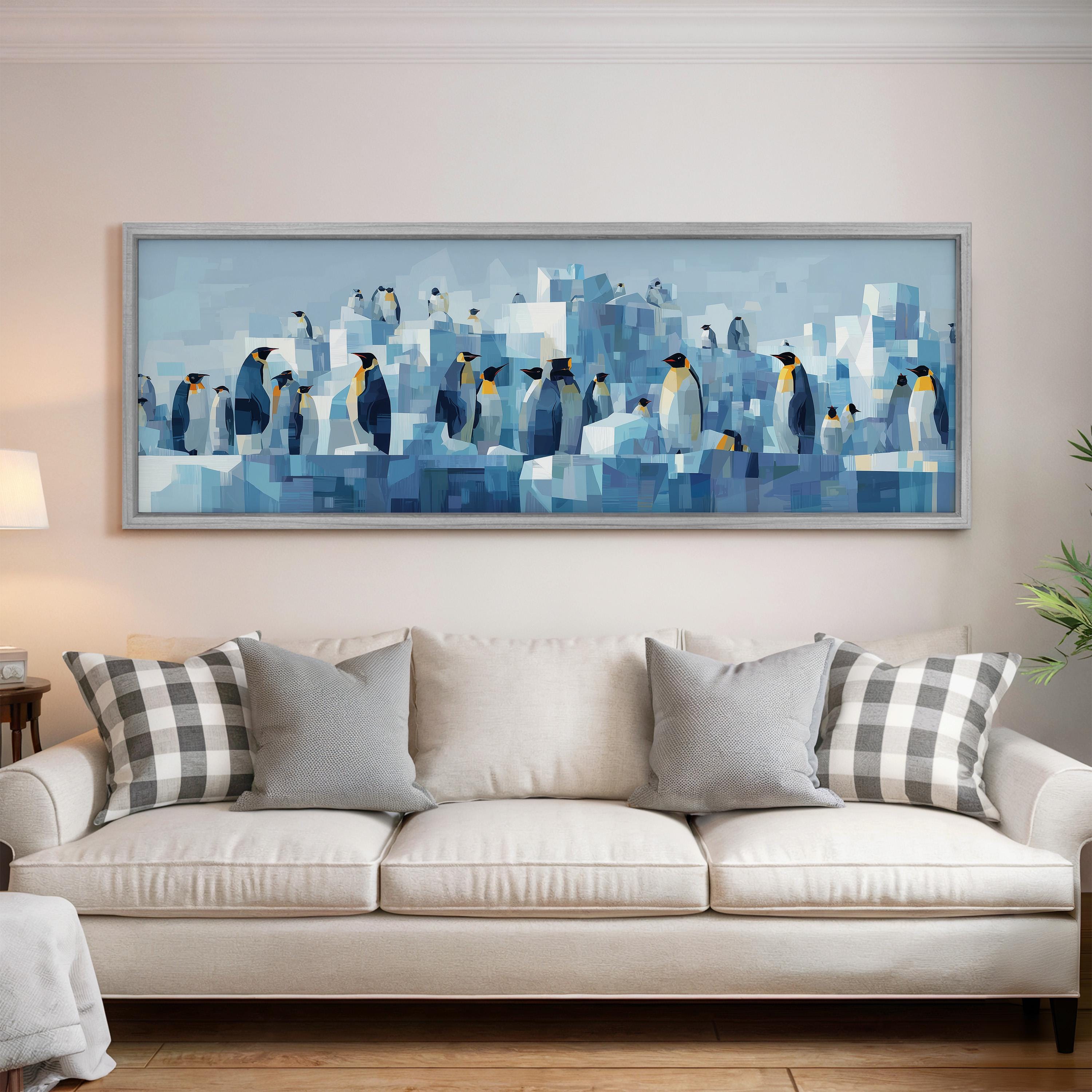 a large, framed painting of penguins on a wall above a white couch with gray and white plaid throw pillows.