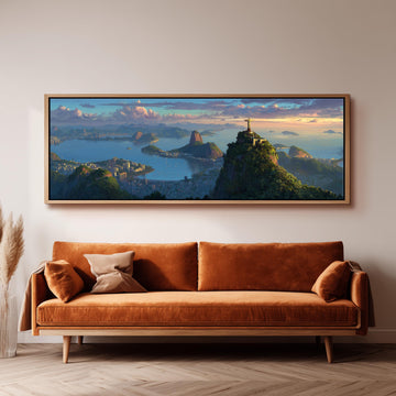 a large, framed painting of a scenic landscape with mountains, a city, and a body of water, hanging on a wall above a brown sofa.