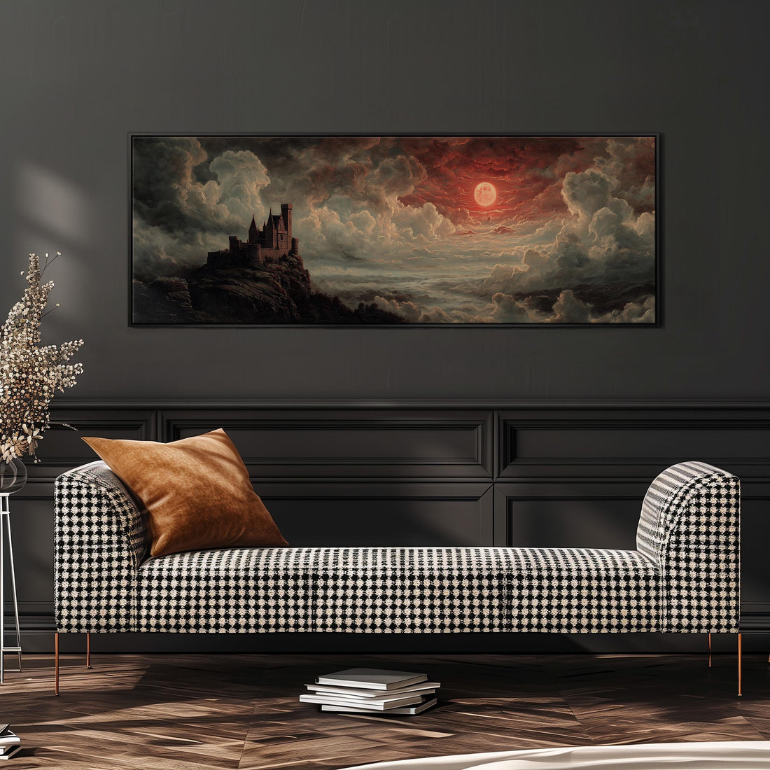 a large painting of a castle on a cliff, with a dramatic sky and clouds in the background. The painting is hanging on a wall above a black and white checkered sofa, which has a brown throw pillow on it. There are also some books on the floor in front of the sofa.
