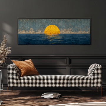 a large painting of a sunset over the ocean, hanging on a wall above a black and white checkered sofa.