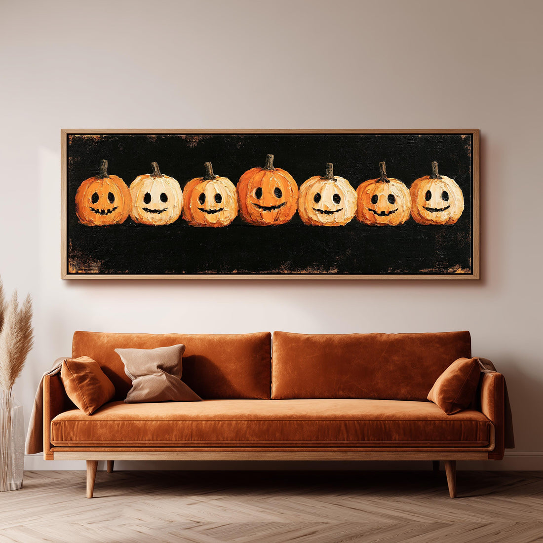 Row of smiling jack-o'-lanterns long horizontal canvas print above a sofa in a living room