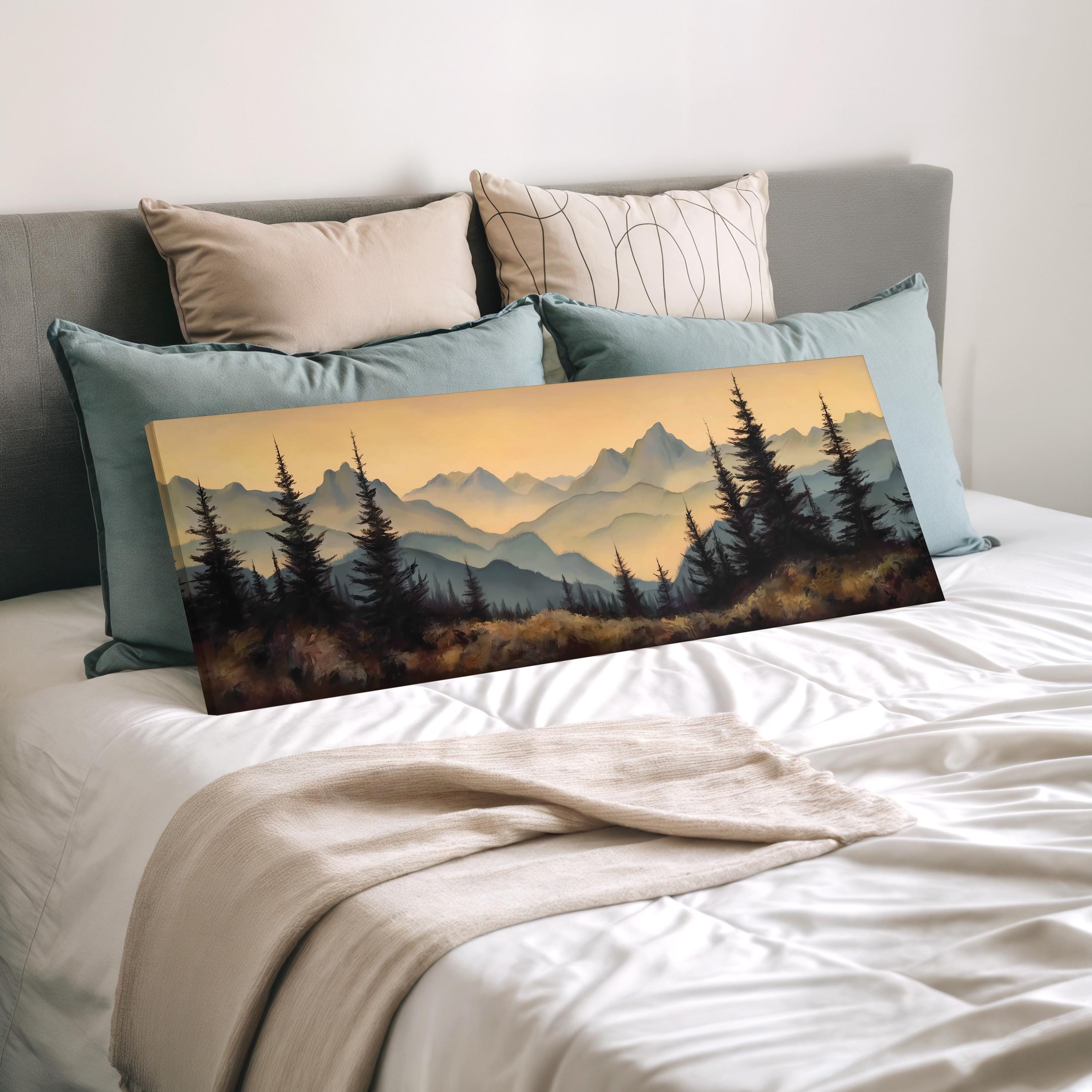 a bedroom with a large landscape painting of a mountain range on the bed, surrounded by pillows.