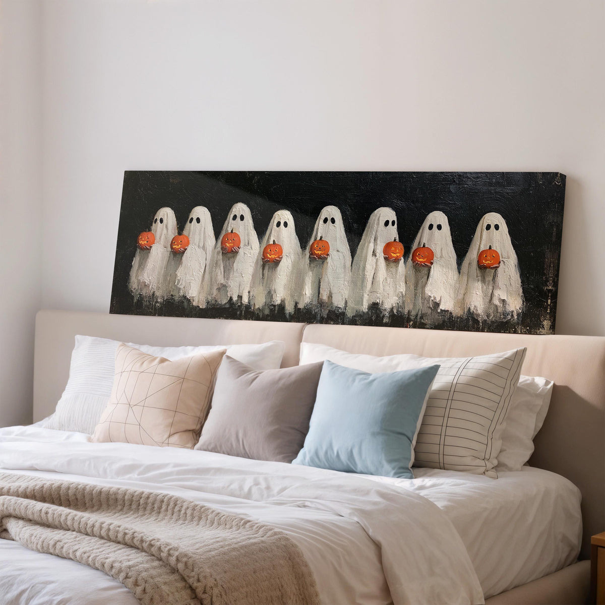 Crowd of huddled ghosts with pumpkins wide panoramic canvas print above a bed in a bedroom