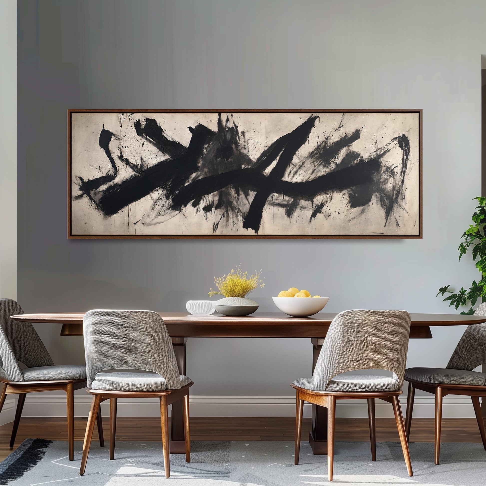 a dining room with a large abstract painting hanging on the wall above a wooden dining table. The table is set with a bowl of fruit and a vase of flowers, creating a cozy and inviting atmosphere. The room is furnished with four chairs, two on each side of the table, and a potted plant is placed on the right side of the room.
