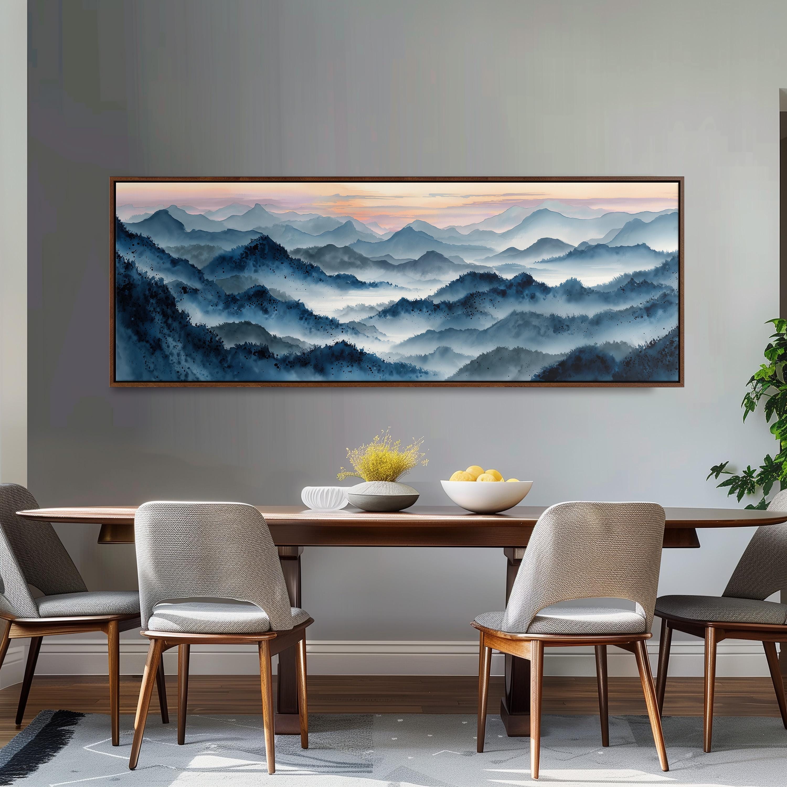 a large painting of a mountainous landscape hanging on a wall above a wooden dining table with four chairs. The painting depicts a serene and picturesque scene of mountains with a hazy, misty atmosphere.