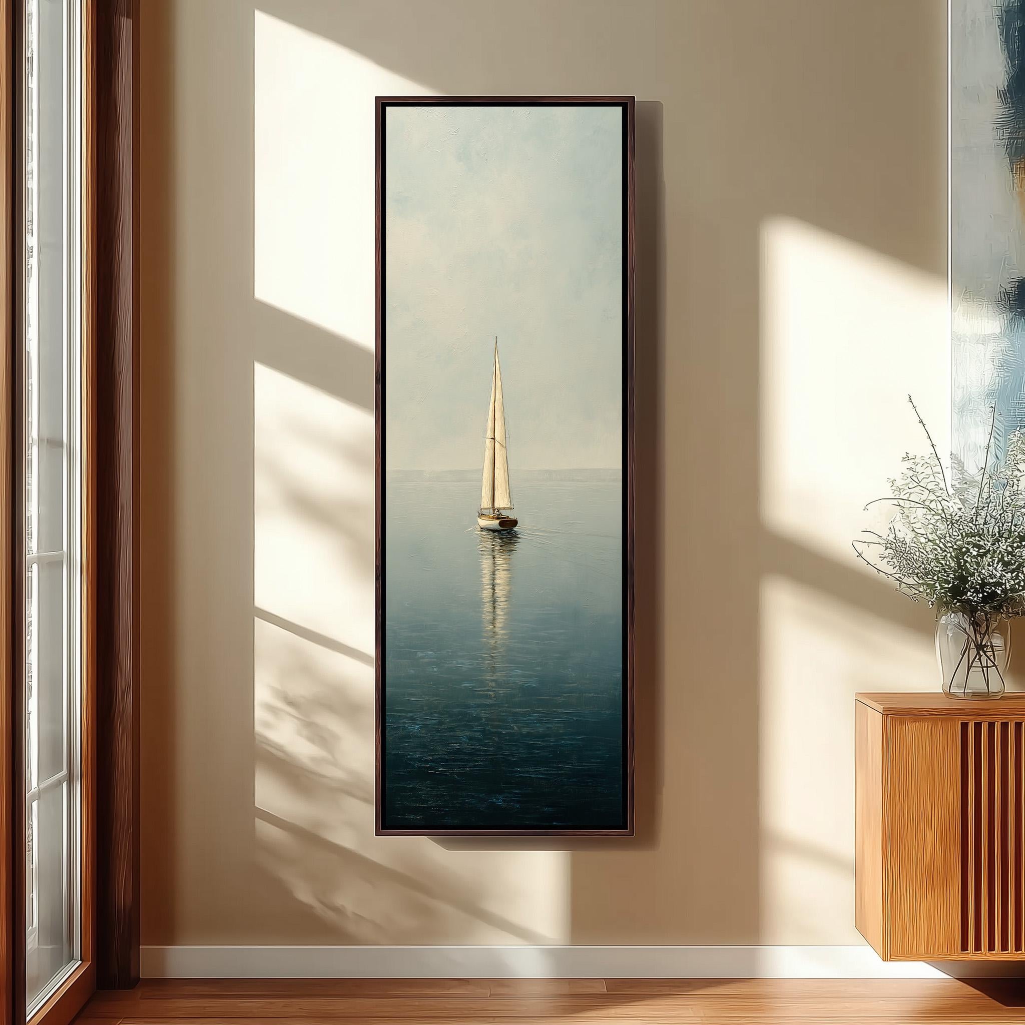 a large framed painting of a sailboat on the water, hanging on a wall in a room with a wooden cabinet and a vase of flowers.