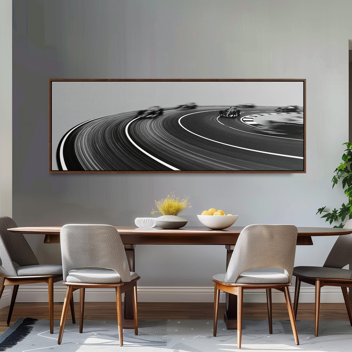 Race cars sweeping around a curve in black and white long horizontal canvas print above a dining table