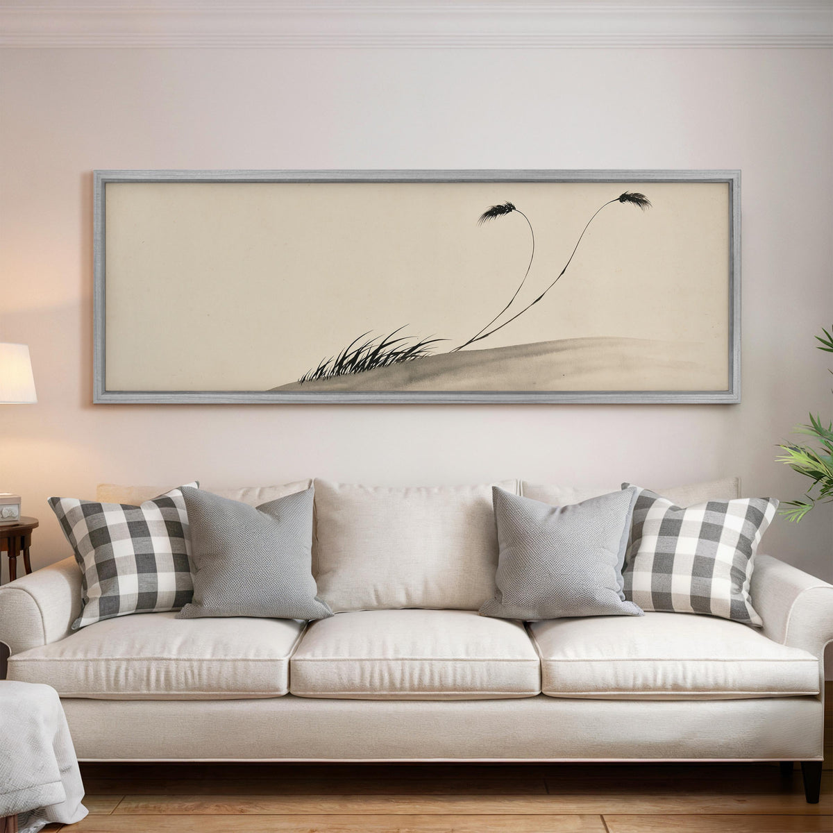 Two birds perched on bending ink reeds panoramic canvas print above a white sofa in a bright living room