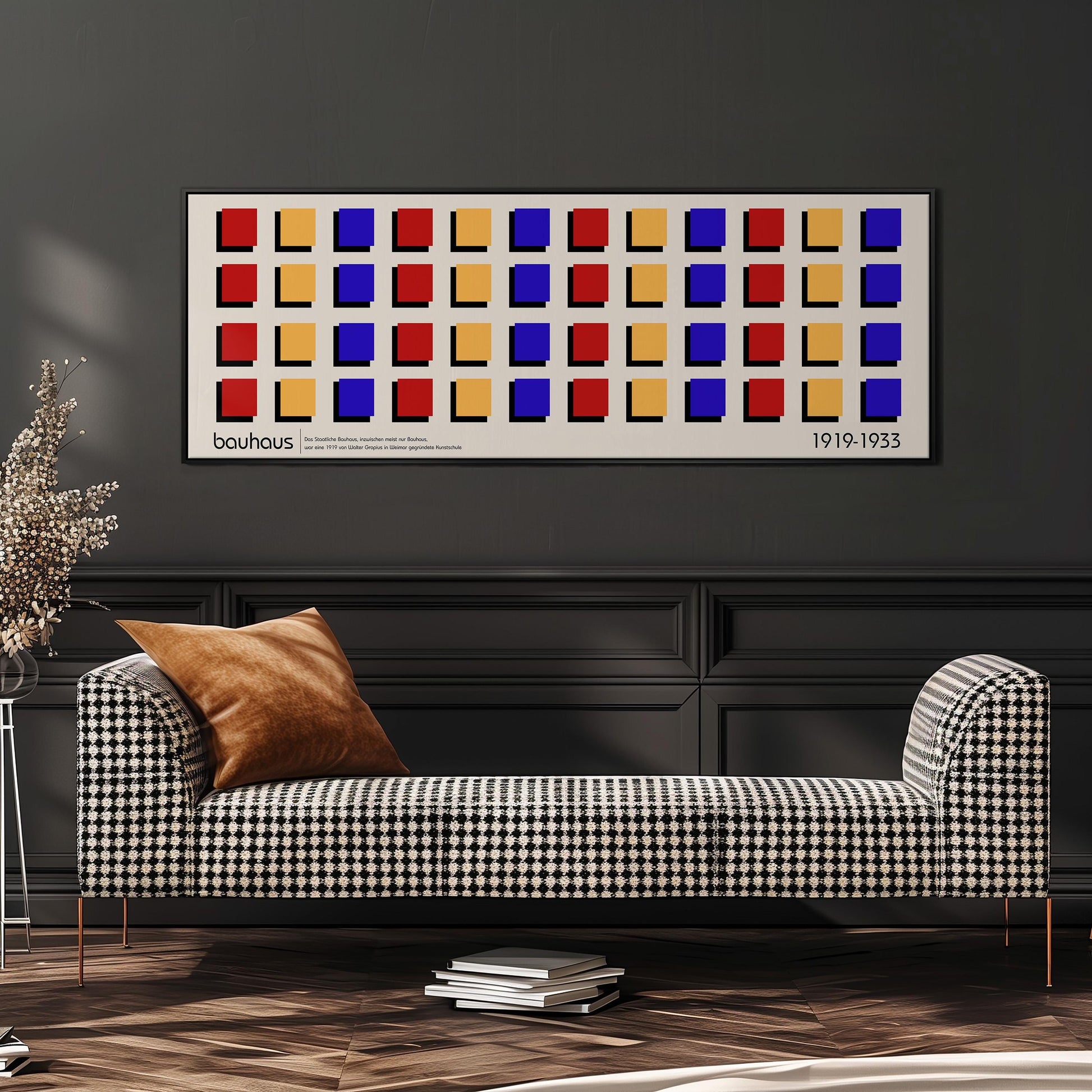 a modern living room with a checkered sofa, a stack of books, and a potted plant. Above the sofa, there is a framed artwork with a geometric pattern of squares in various colors.
