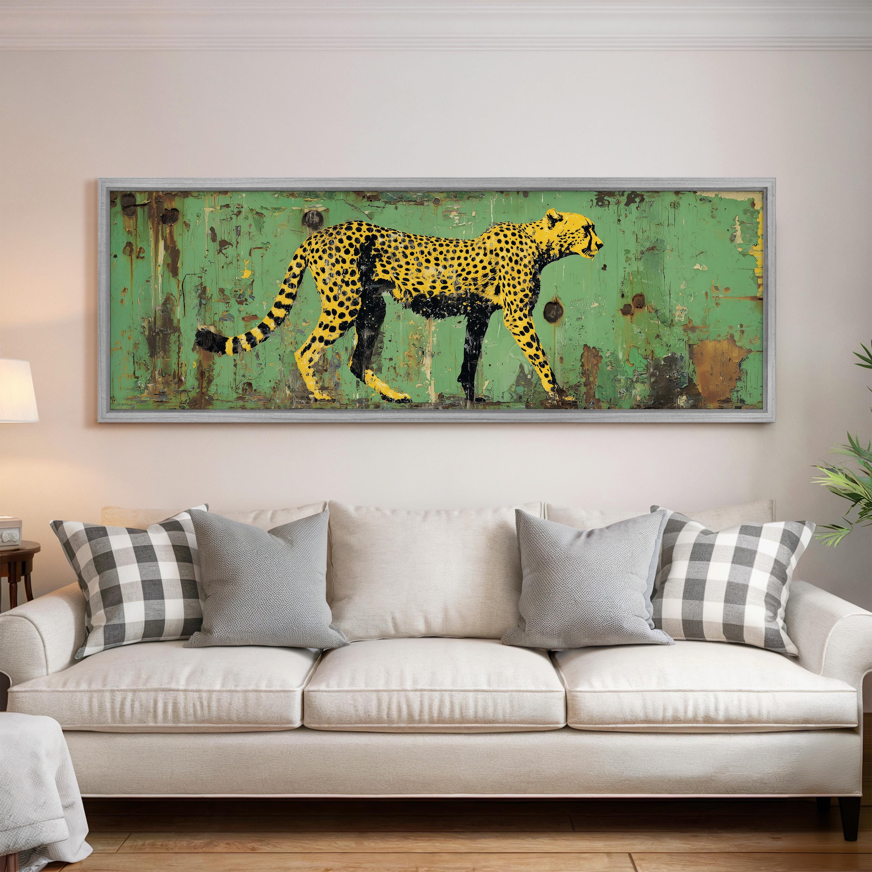 a large framed painting of a cheetah on a green background, hanging on a wall above a white couch with gray and white plaid throw pillows.