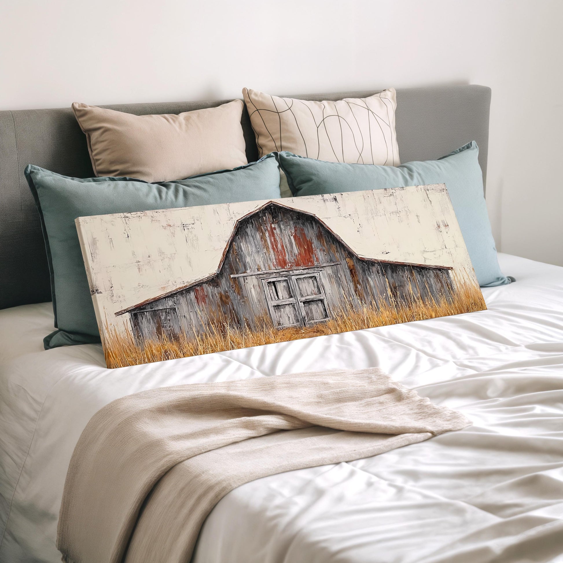 a bedroom setting with a bed and a painting of a barn on the bed.