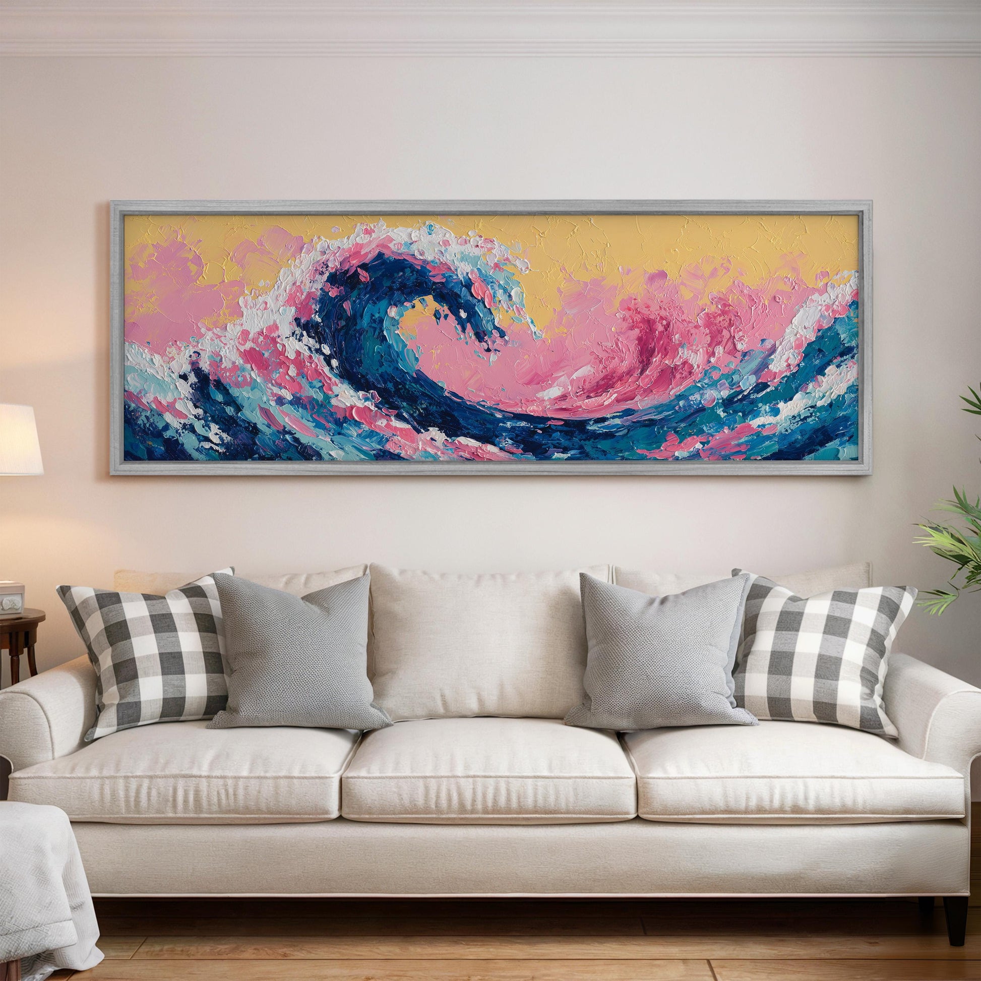 a large, colorful painting of a wave hanging on a wall above a white couch with gray and white plaid throw pillows.