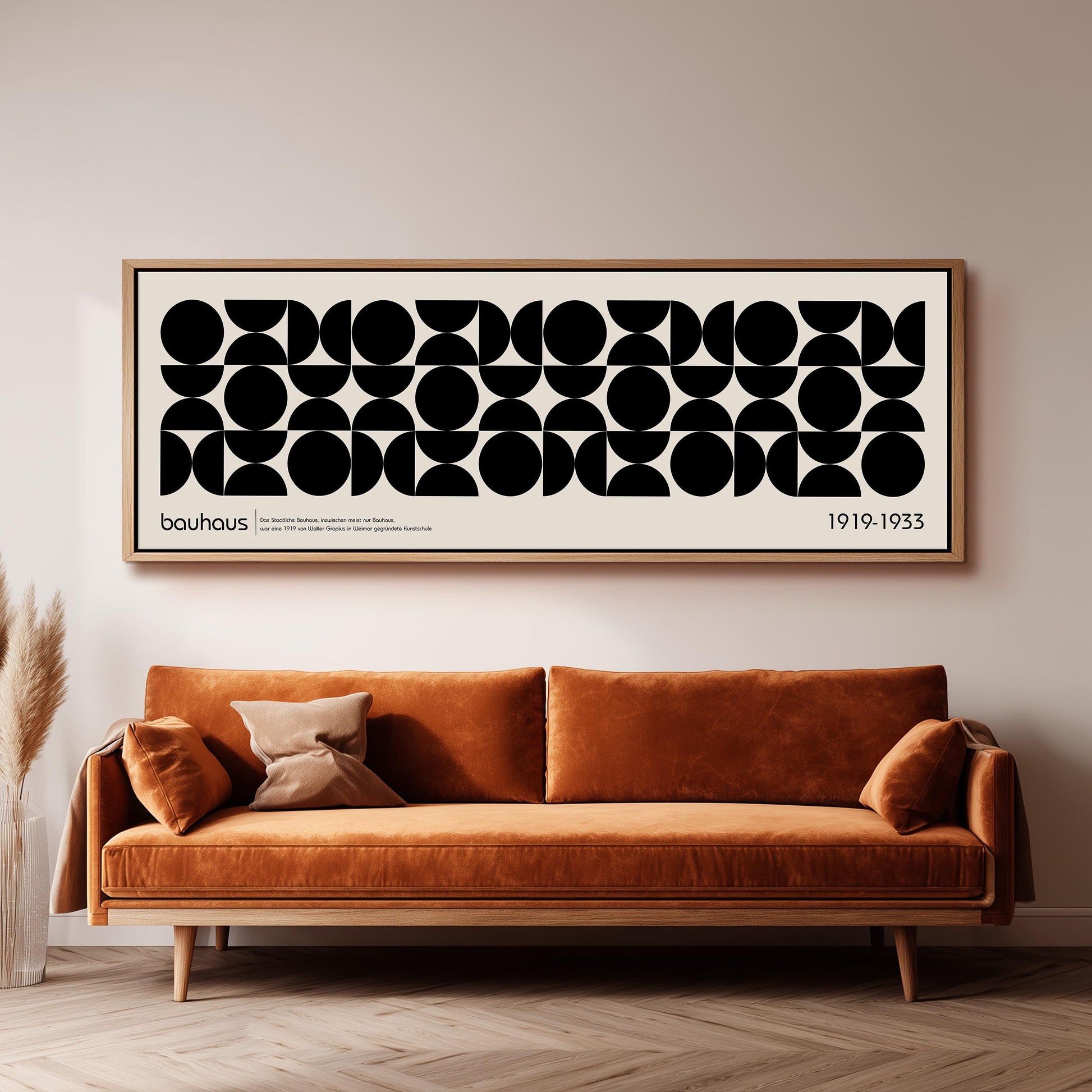 a large black and white abstract art piece hanging on a wall above a brown sofa.