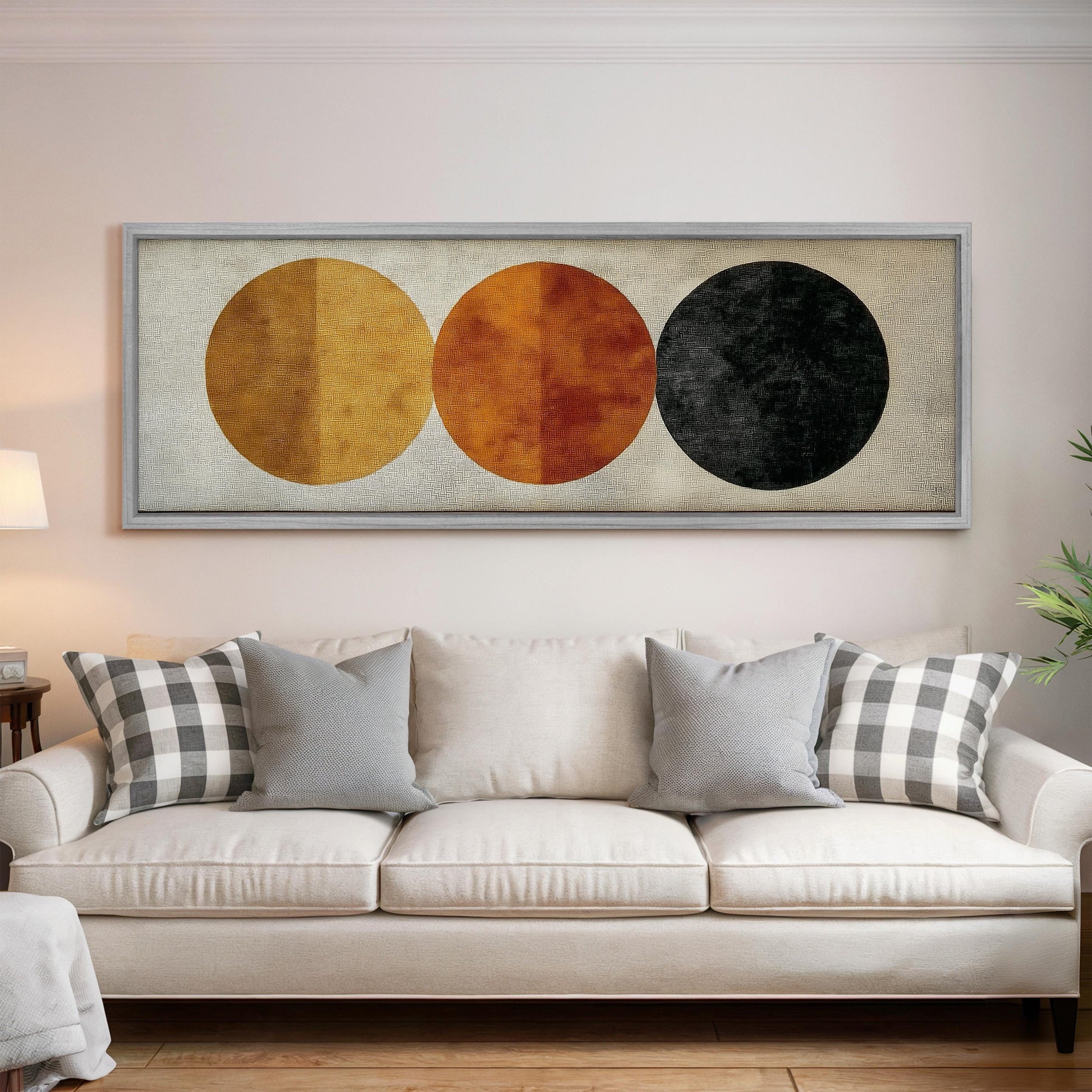 a living room with a white sofa and a framed artwork hanging on the wall above it.