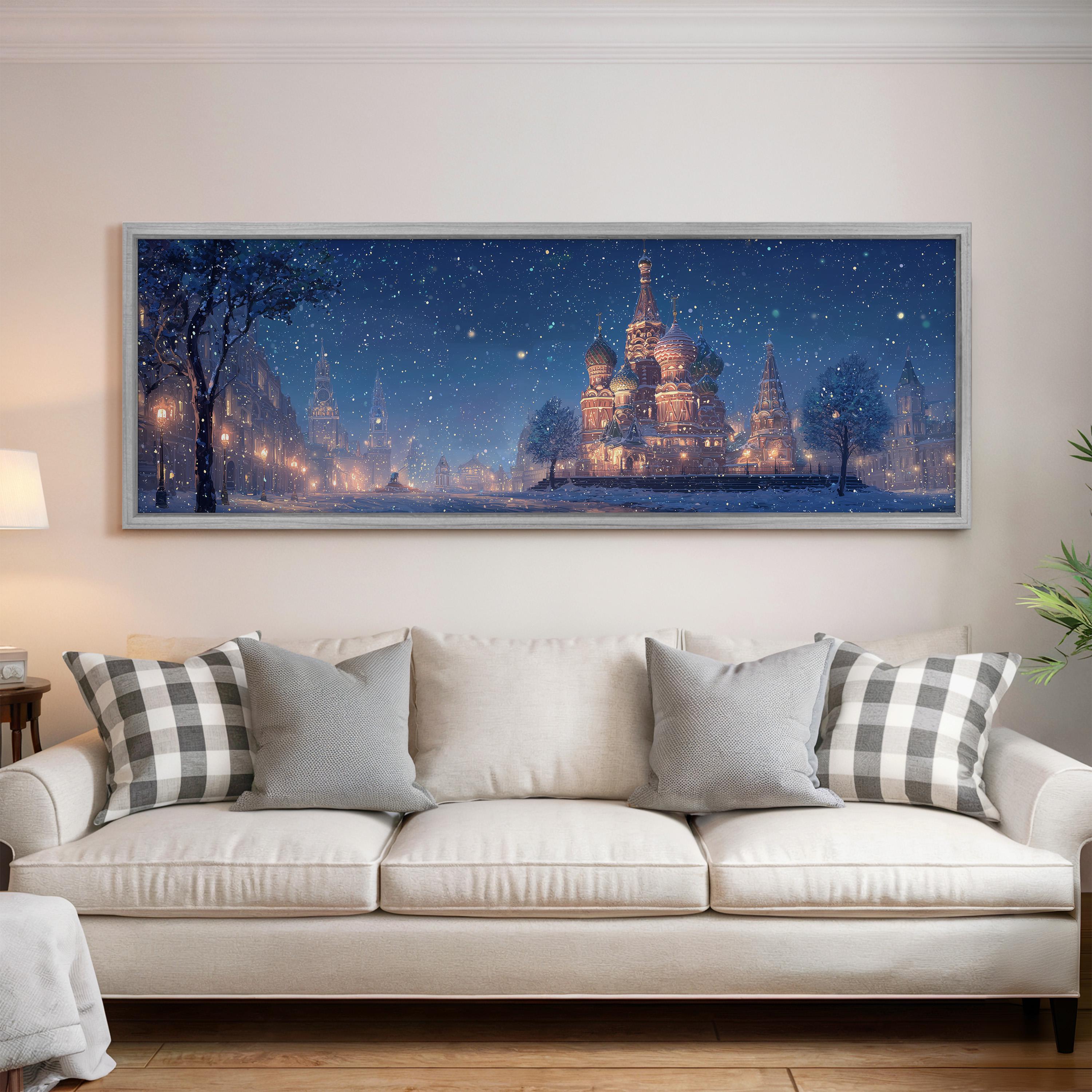 a large, framed painting of a snowy cityscape with a castle in the background, hanging on a wall above a white couch with patterned pillows.