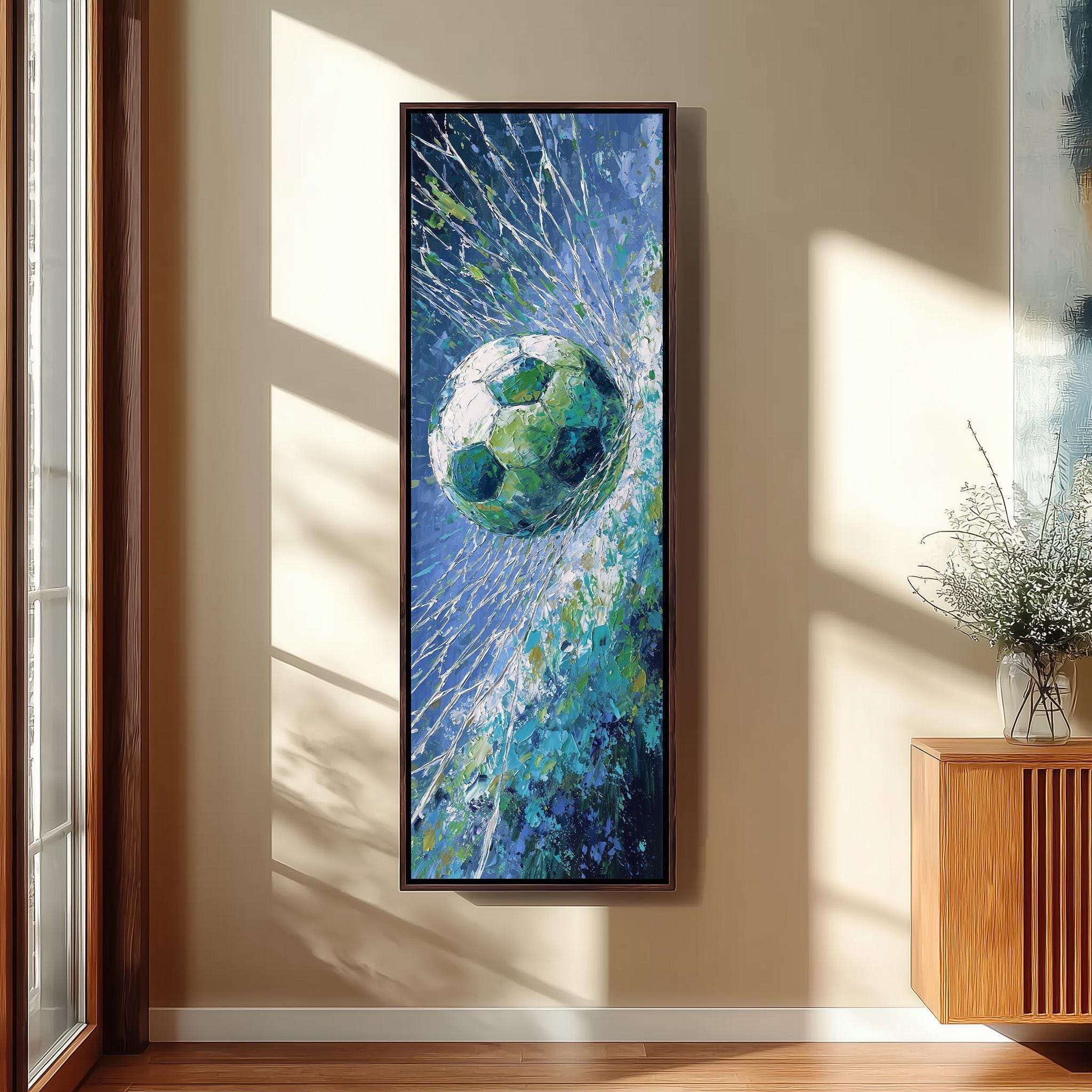 a large, colorful painting of a soccer ball suspended in mid-air, with a blue and green background and a white and green soccer ball. The painting is hanging on a wall in a room with a wooden cabinet and a vase of flowers.