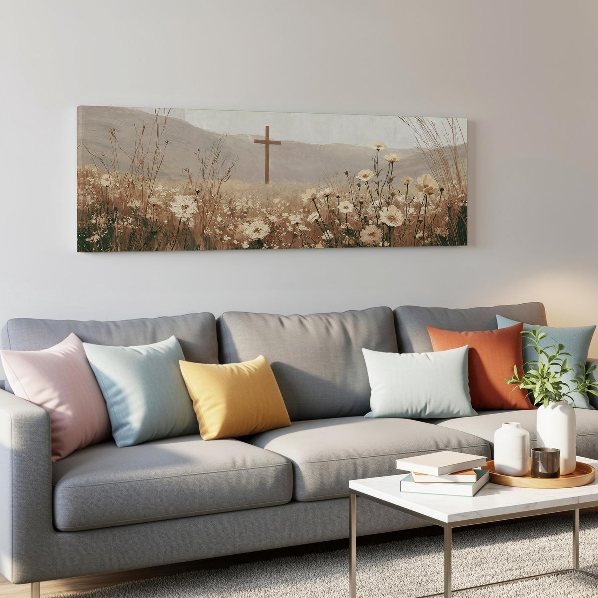 Wooden cross in a cream wildflower field panoramic canvas print above a grey sofa in a living room