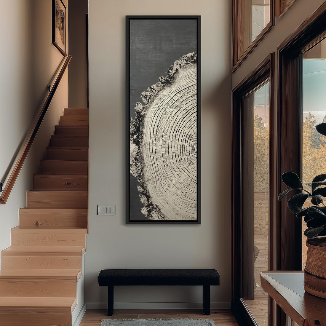 a hallway with a large tree trunk painting hanging on the wall, a wooden staircase, a black bench, and a potted plant.