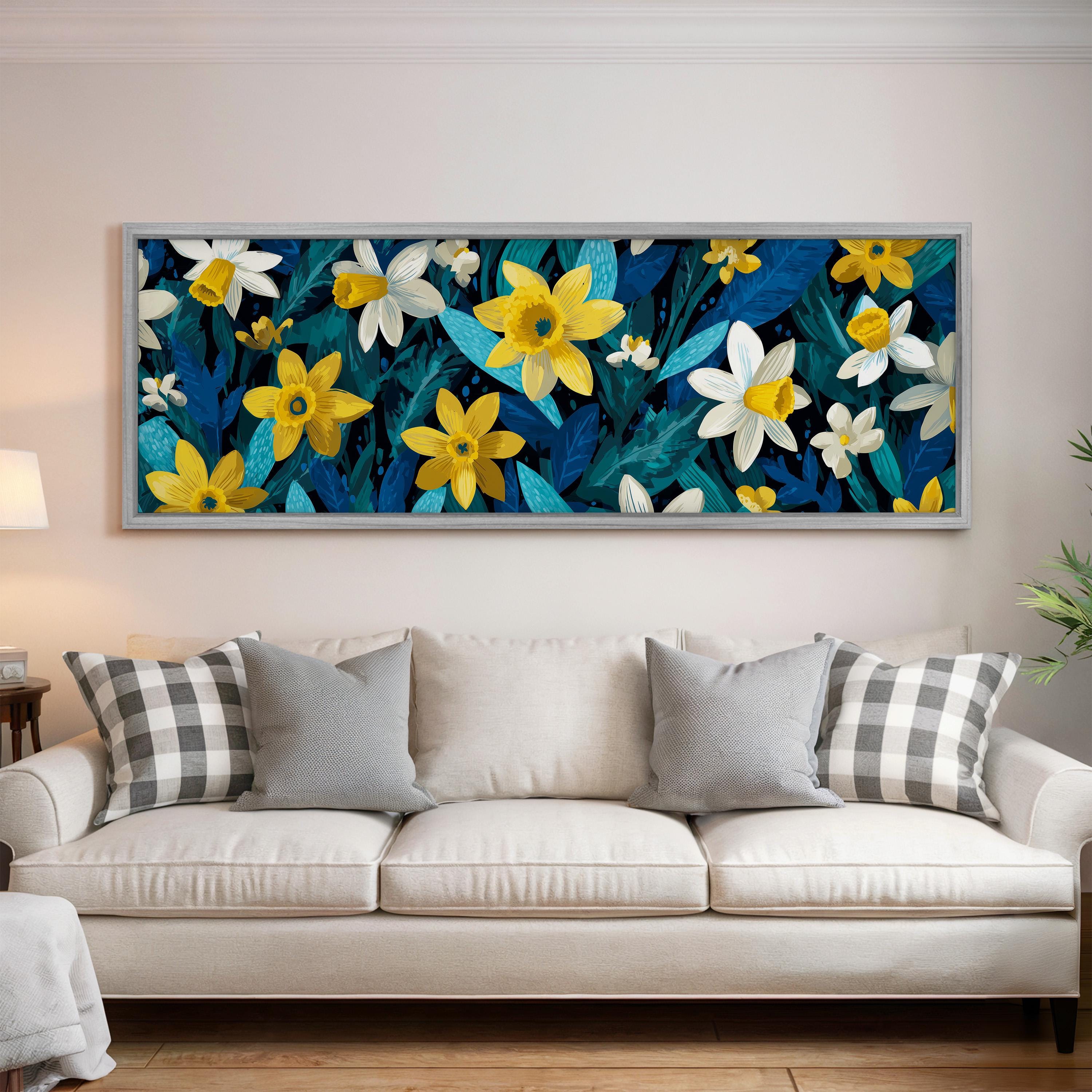 a large, colorful painting of yellow and white flowers hanging on a wall above a white couch with gray and white pillows.