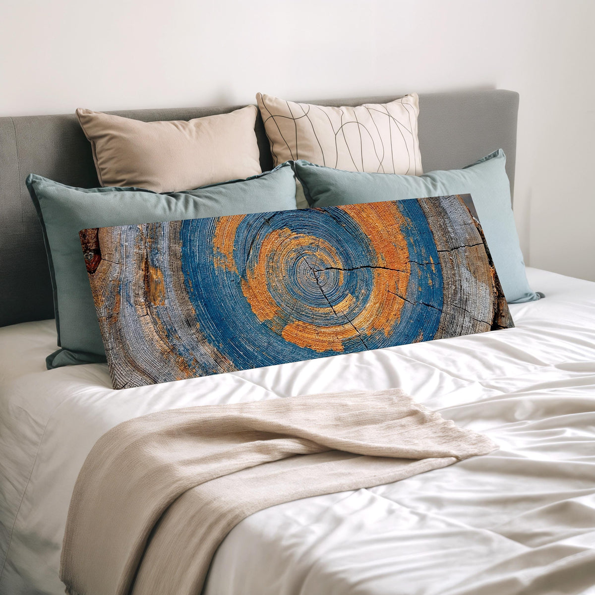 Blue and orange tree ring wide panoramic canvas print laid on a bed to show its size