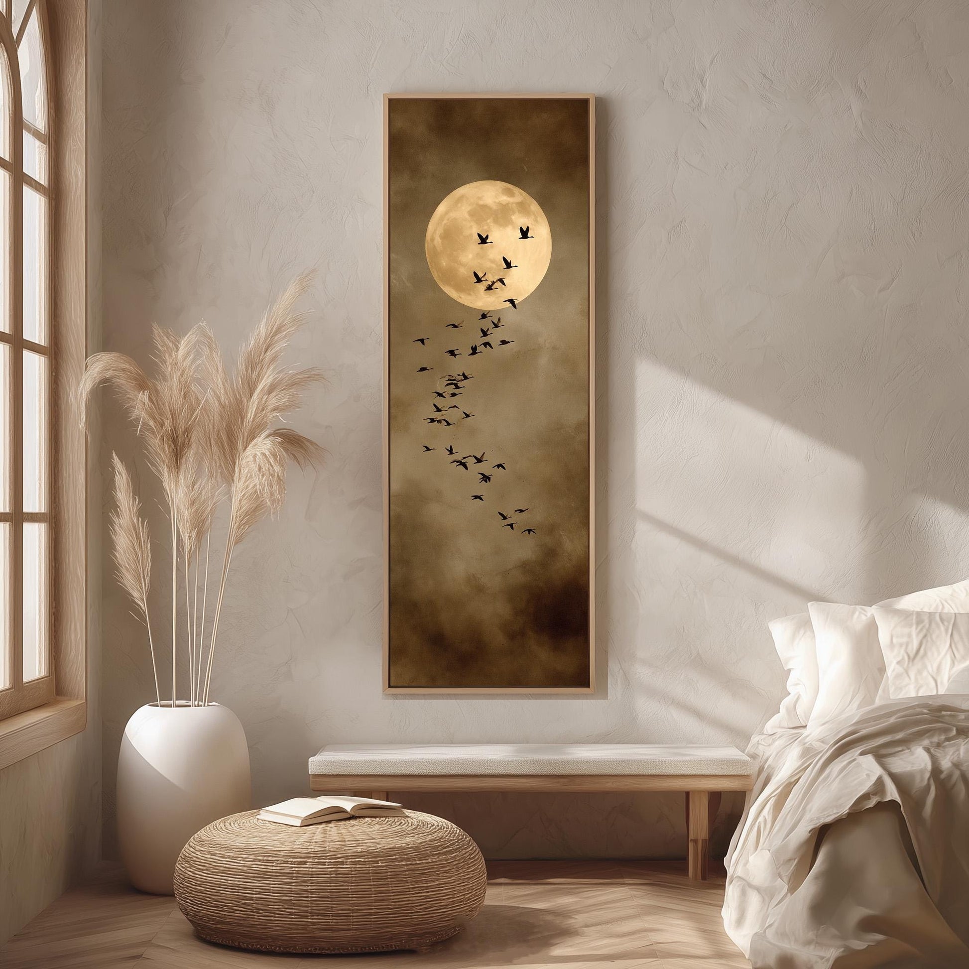 a serene bedroom scene with a large framed picture of a full moon and a flock of birds on the wall. The room is decorated with a white bed, a wicker ottoman, and a potted plant.