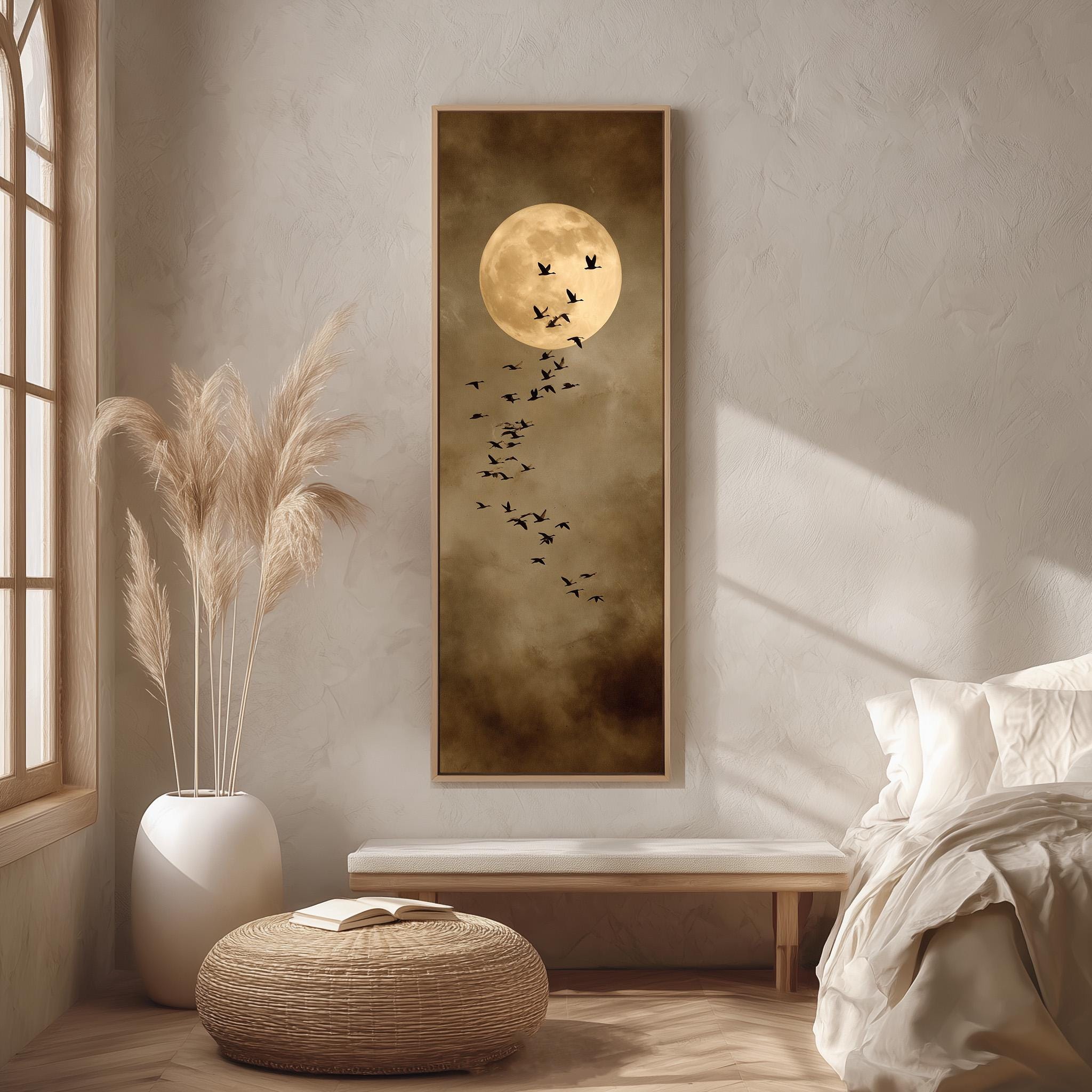 a serene bedroom scene with a large framed picture of a full moon and a flock of birds on the wall. The room is decorated with a white bed, a wicker ottoman, and a potted plant.