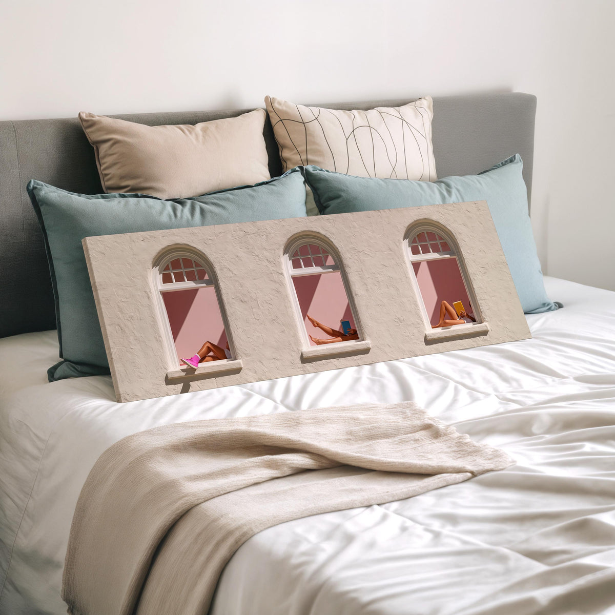 Women reading in three arched windows wide panoramic canvas print laid on a bed to show its size