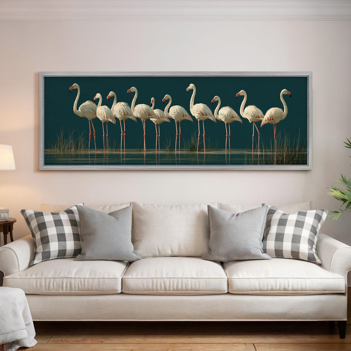Pale flamingos wading on teal panoramic canvas print above a white sofa in a bright living room