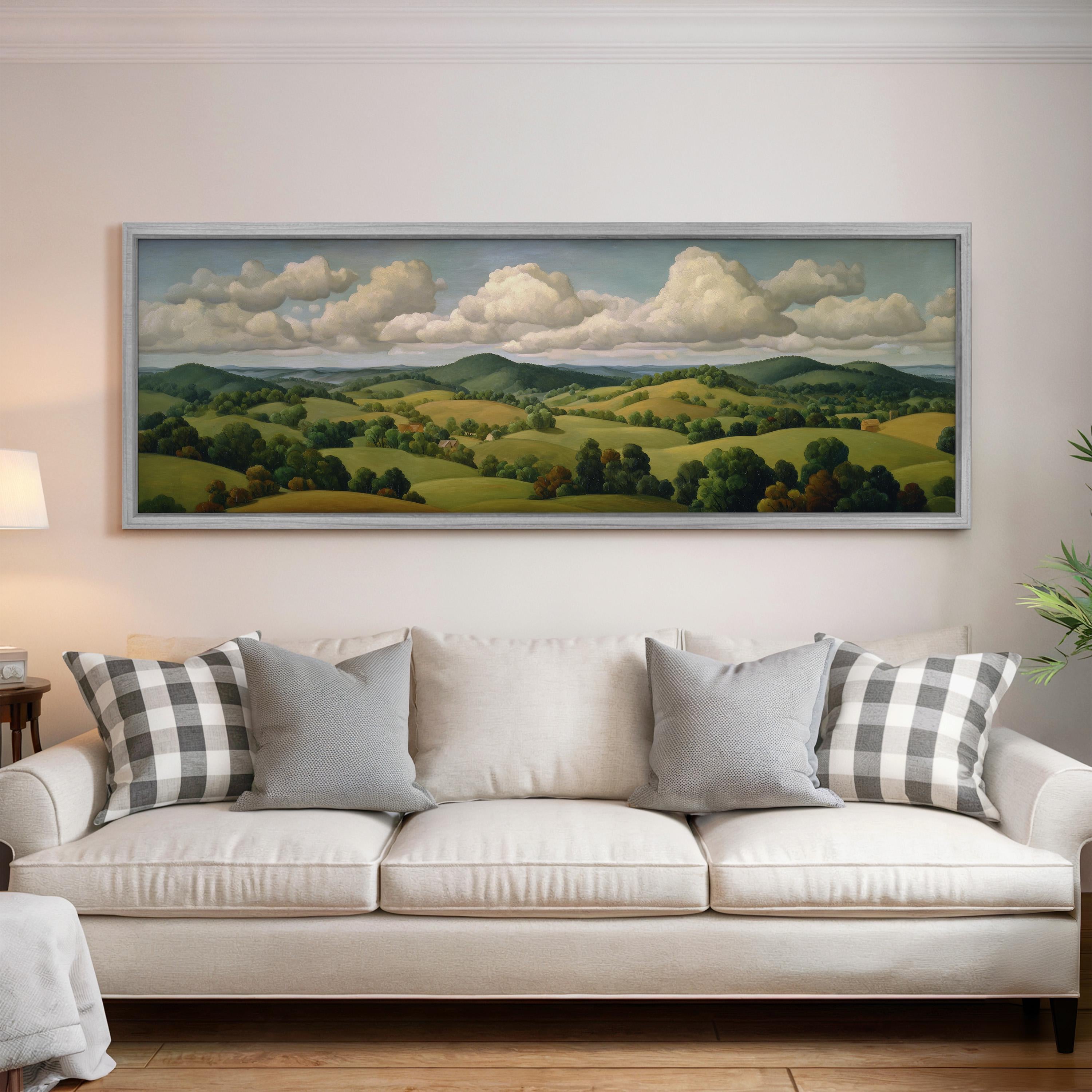 a large landscape painting hanging on a wall above a white sofa with gray and white plaid throw pillows.