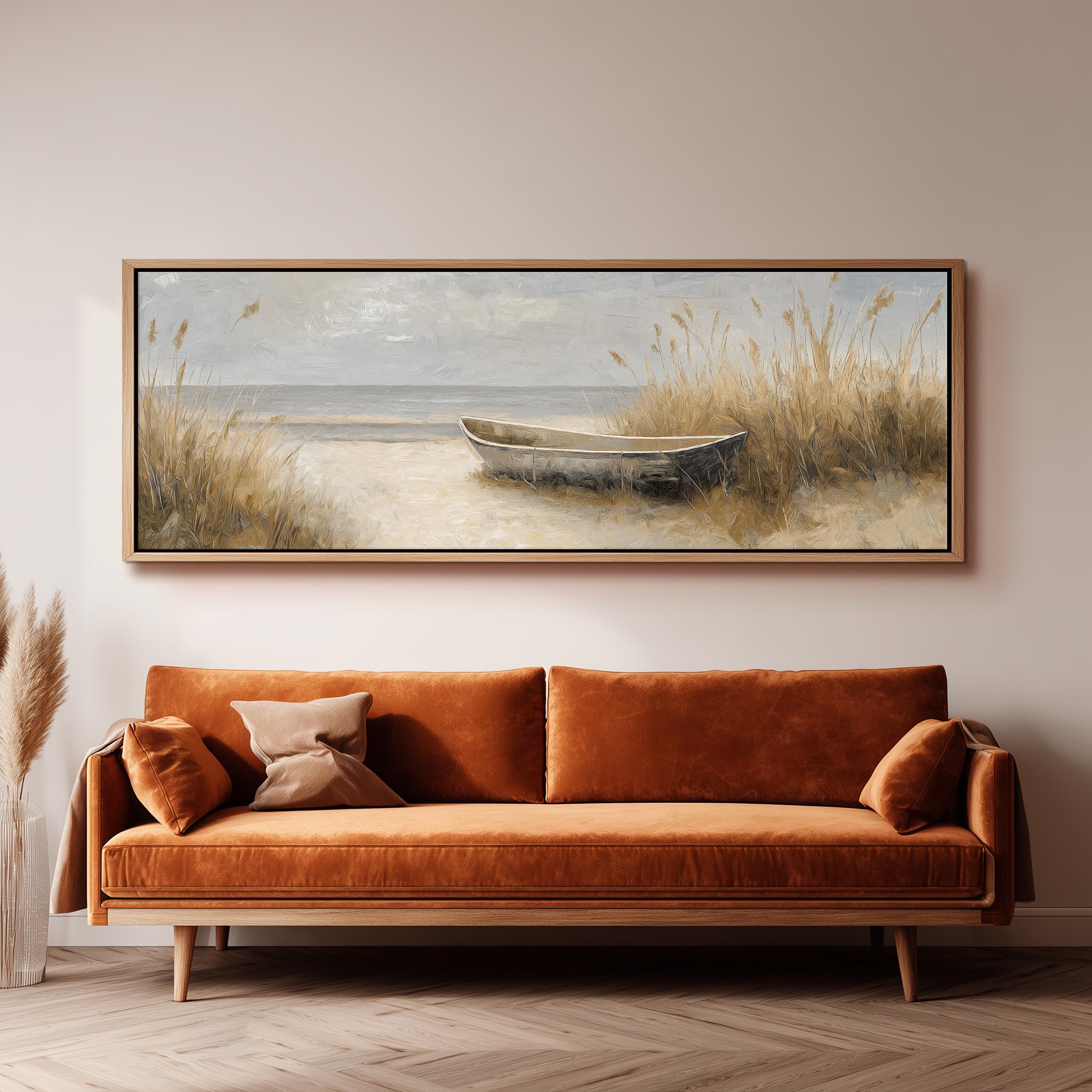 a large painting of a boat on the beach, hanging on a wall above a brown sofa.