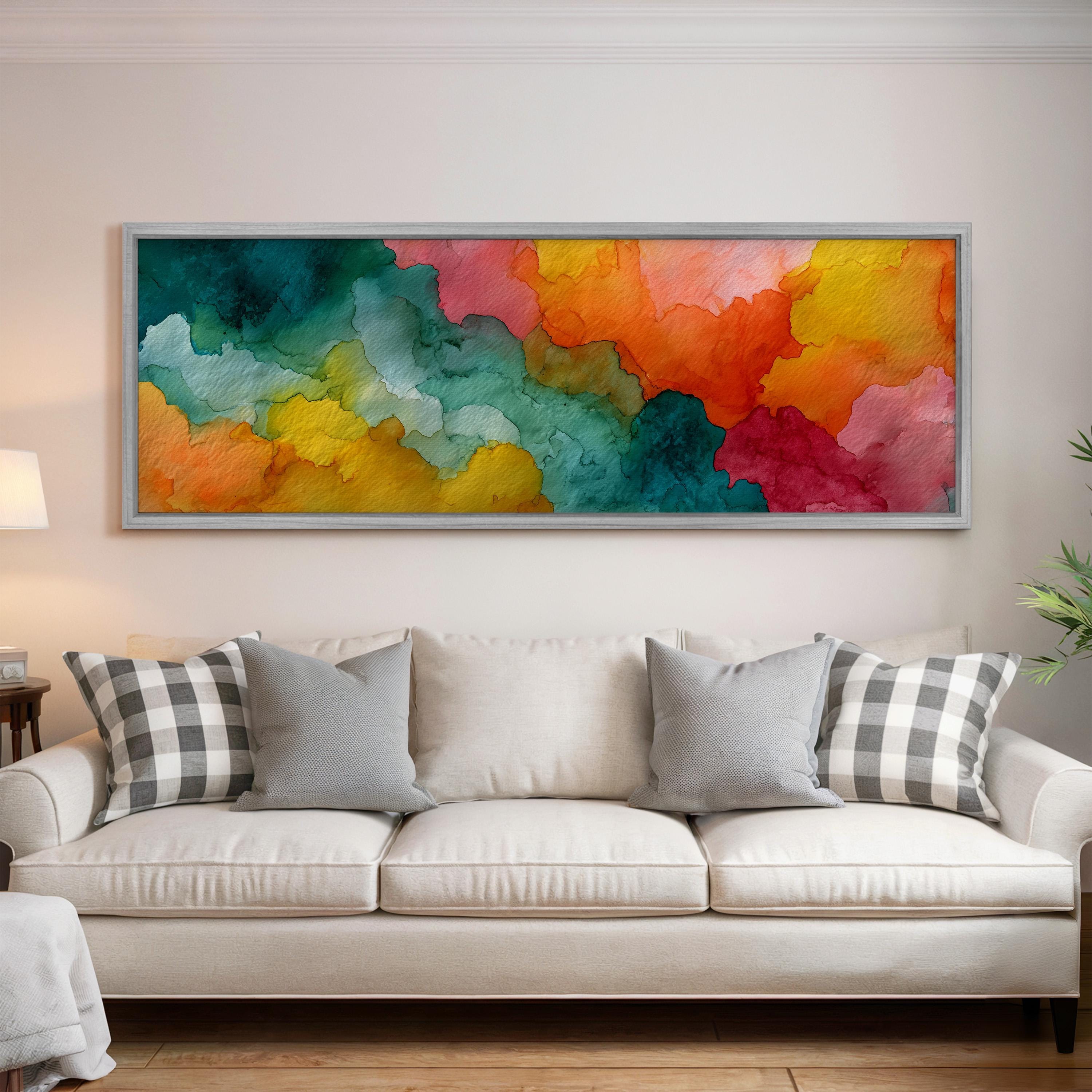 a large, colorful abstract painting hanging on a wall above a white couch with gray and black plaid throw pillows.