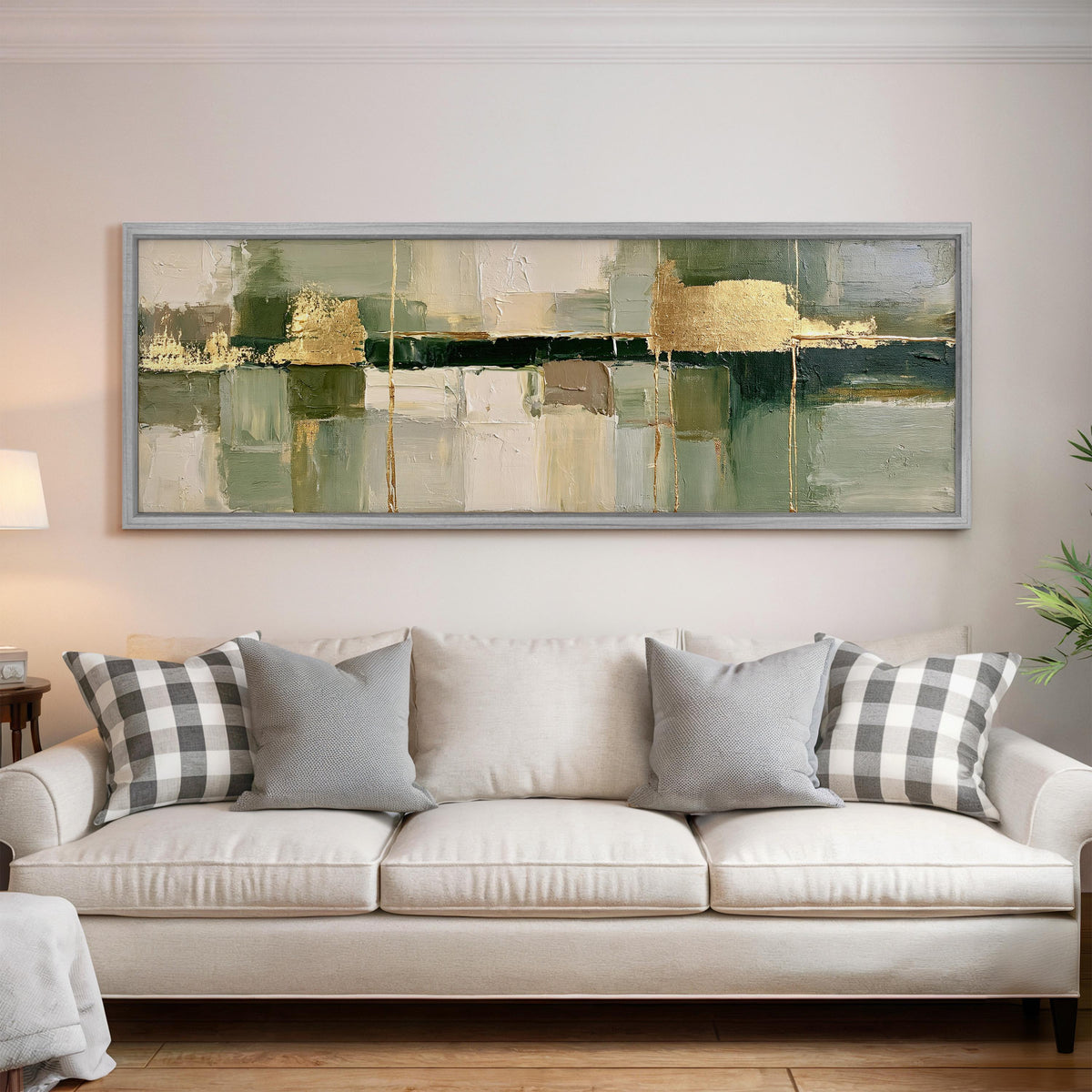 Sage and gold leaf abstract panoramic canvas print above a white sofa in a bright living room