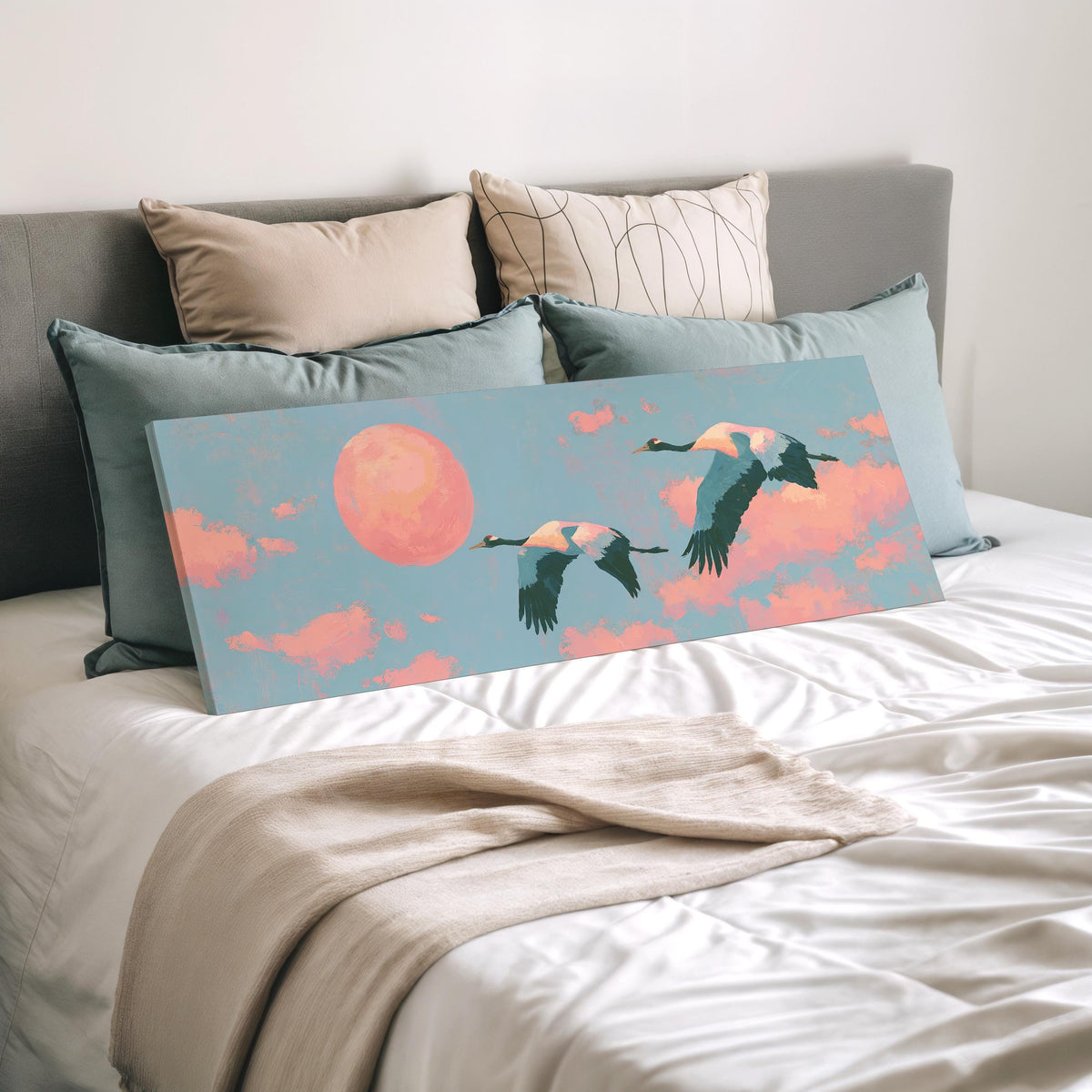 Two cranes flying at sunset wide panoramic canvas print laid on a bed to show its size