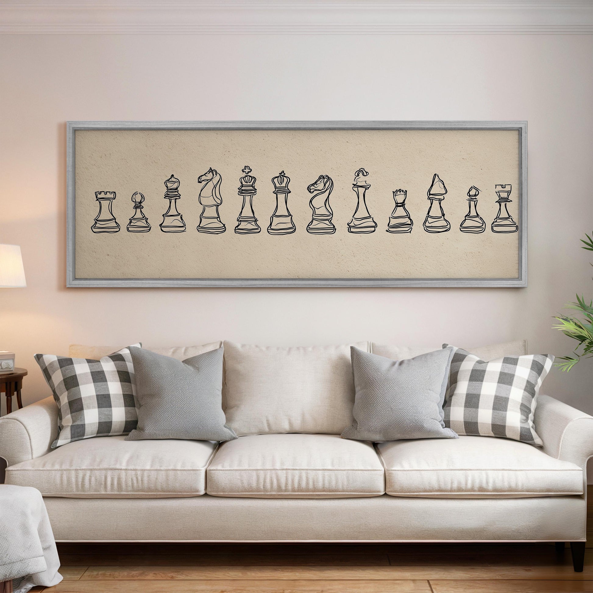 a living room with a white sofa and a framed artwork of chess pieces on the wall above it.