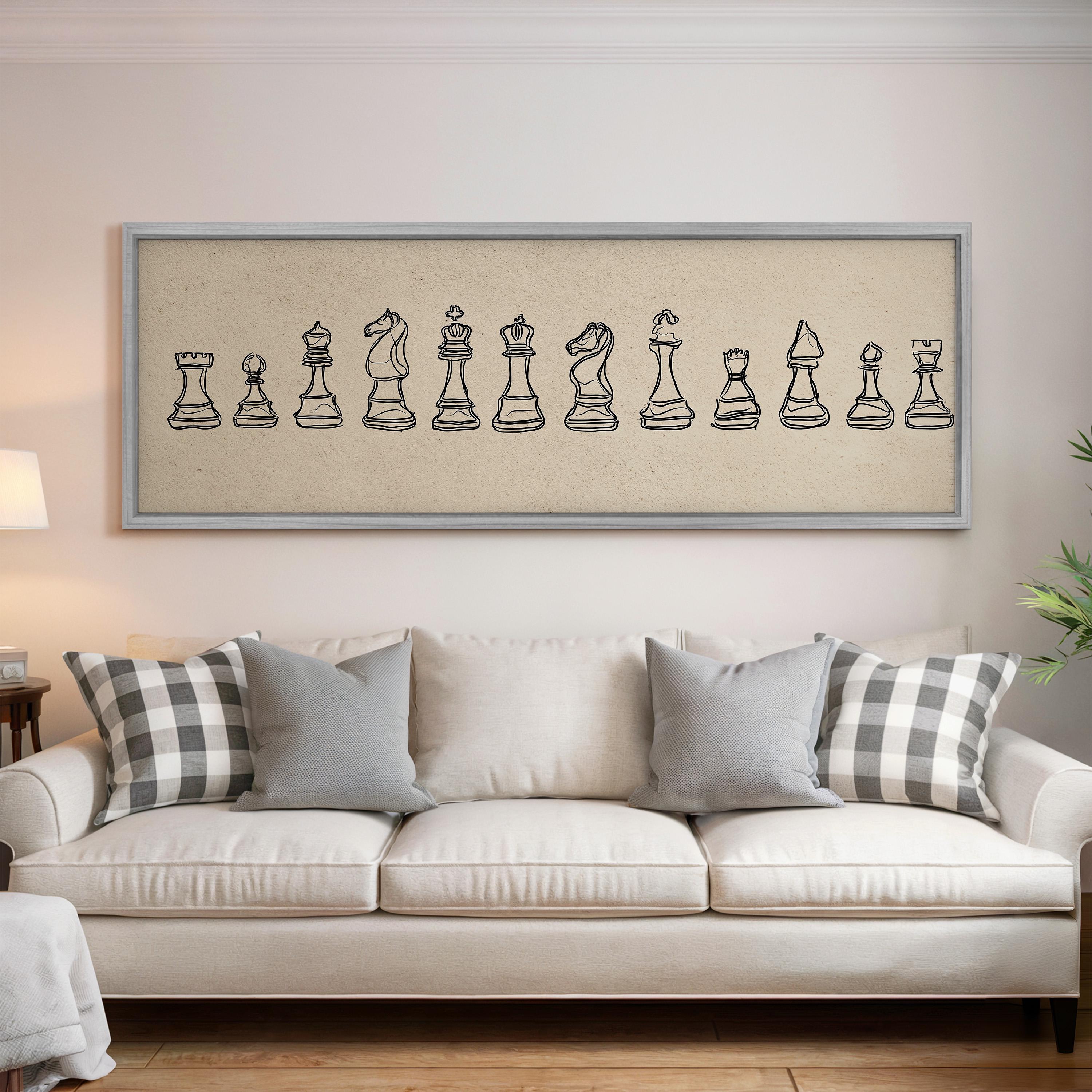 a living room with a white sofa and a framed artwork of chess pieces on the wall above it.